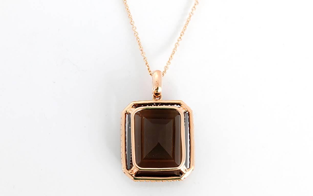  This stunning necklace features a 20.15 ct emerald cut smoky quartz bordered by 0.16ct round white diamonds set in 18k rose gold on a 14k rose gold chain. Chain measures apx. 18-inches in length. Pendant measures apx. 3/4-inch in width and