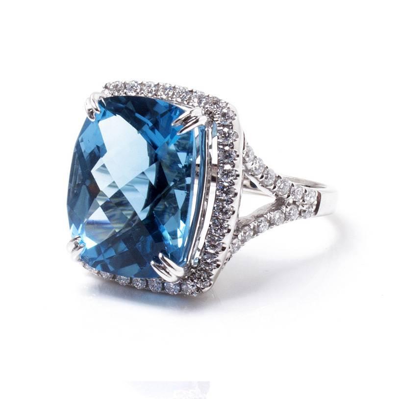 This beautiful ring features a 12.0ct checkerboard blue topaz (16 x 12 cushion) and 0.78ct round diamonds set in 14k white gold. Total weight is 8.9 grams. Size 7. This ring is absolutely stunning for special occasions and evenings!