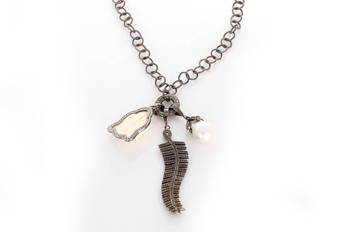 This beautiful bohemian inspired necklace features baroque pearl and feather pendants with an oxen bone Buddha pendant outlined by diamonds on a diamond oval clasp; all set in oxidized sterling silver. Sterling silver chain measures apx. 36-inches