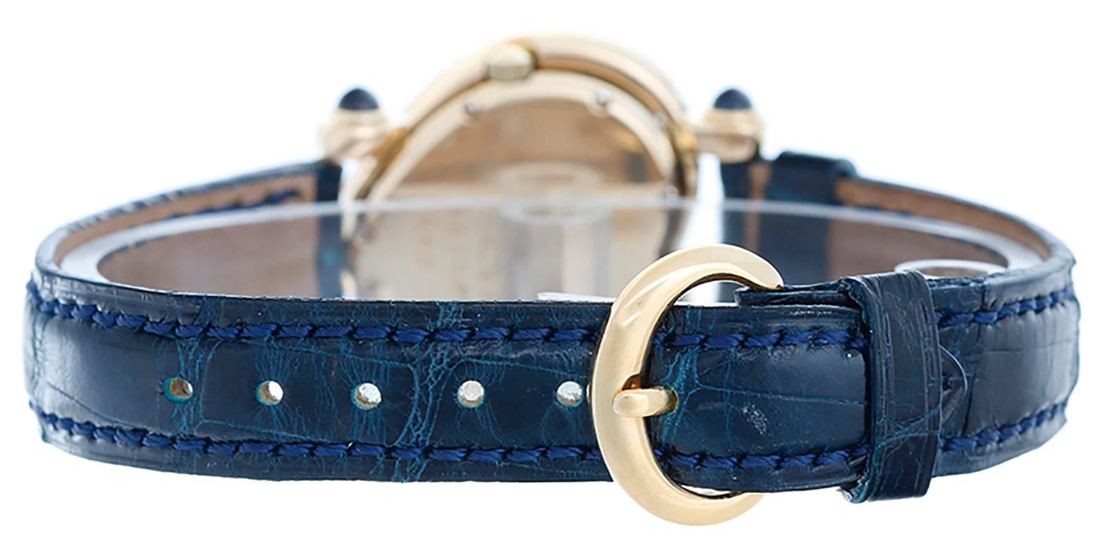 Quartz movement. 18k yellow gold heart shaped case with 18 diamonds and blue sapphire cabochons on the lugs (30mm x 30mm). Blue mother of pearl dial with 3 floating diamonds. Dark blue Chopard strap band and 18k yellow gold buckle. Pre-owned with