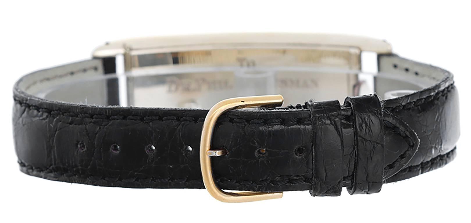 Manual winding. Large rectangular curved 14k yellow gold hinge-back case with crown at 12 o'clock position (22mm x 55 mm); presentation watch with engraving on case back. Ivory colored dial with gold Breguet numerals; subseconds dial. Strap band.