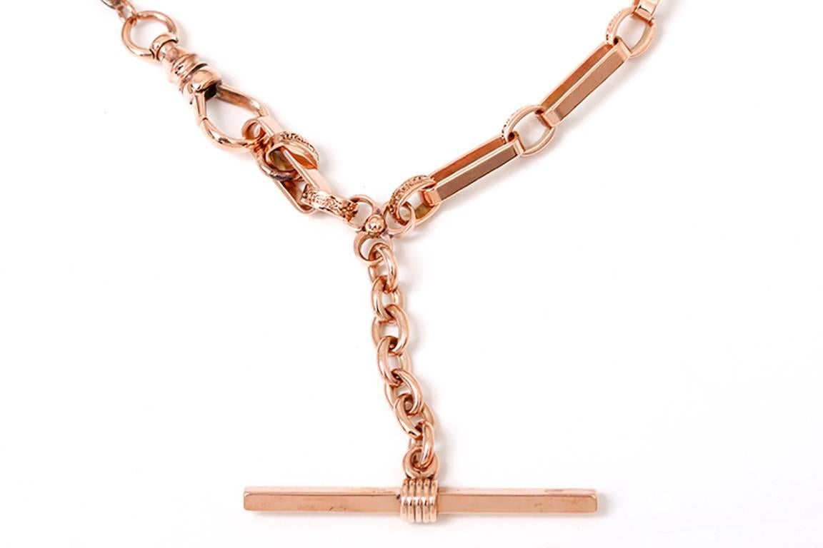 Rose gold pocket watch chain measures apx. 13-in. in length and weighs 23.9 grams. The smaller oval links are ornately engraved, while the longer (apx. 1/2-inch) links are smooth.
