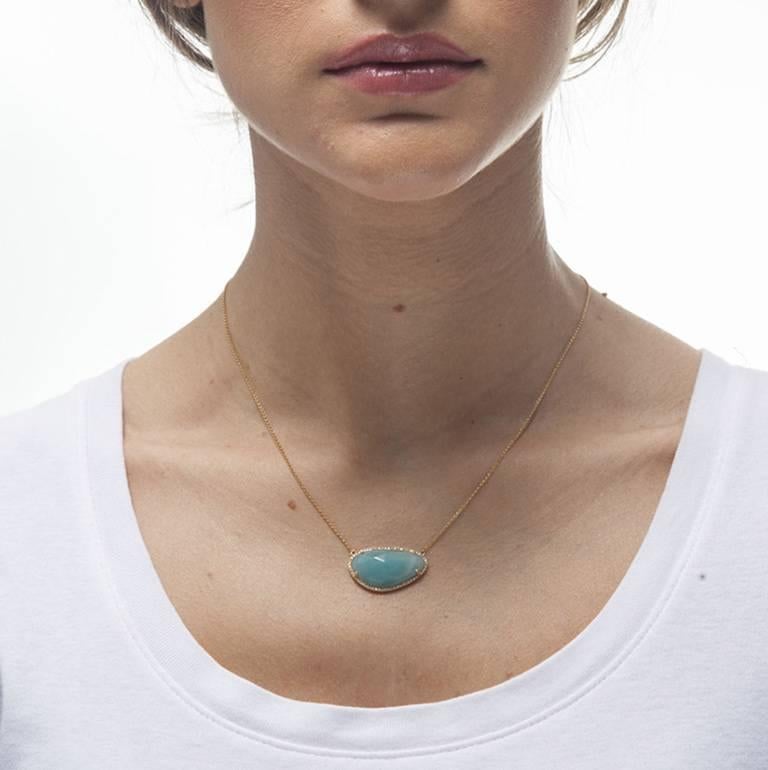 This  necklace features a 10.08 carat green amazonite bordered by 0.17 carats of diamonds set in 14k yellow gold.  The pendant measures apx. 1- inch in width at the widest and apx. 5/8-inch in length at the longest.  The chain measures apx.