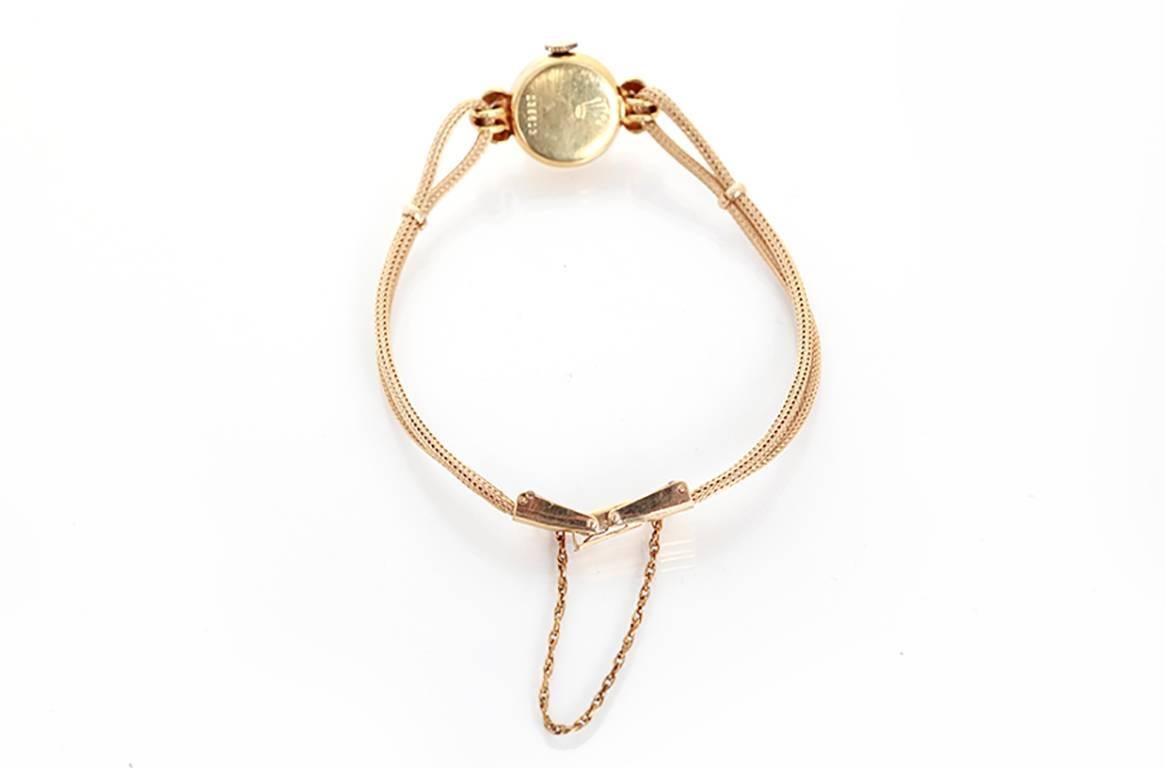 Manual winding. 14k yellow gold case  (15mm diameter). Ivory colored dial with gold stick markers. Extra long 14k yellow gold double rope bracelet (will fit apx. 7-1/4 inch wrist and can be sized). Very unusual and rare vintage Rolex ca. 1940's.