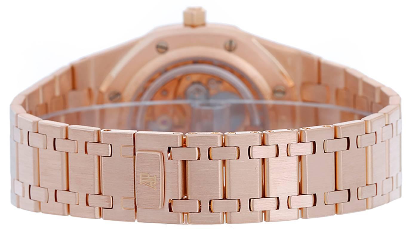 Automatic winding. 18k rose gold case (39mm diameter). Gold colored dial with day, date, month and moonphase. 18k rose gold Royal Oak bracelet (will fit apx. 7-inch wrist). Pre-owned with Audemars Piguet box and papers.