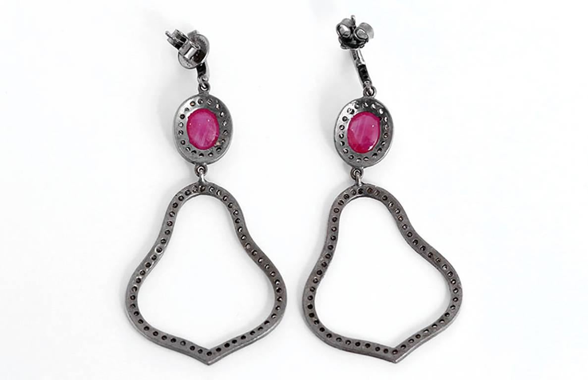These amazing earrings each feature a ruby cabochon with diamonds set in oxidized sterling silver. Earrings measure apx. 2-3/4 inches in length. Total weight is 8.5 grams.