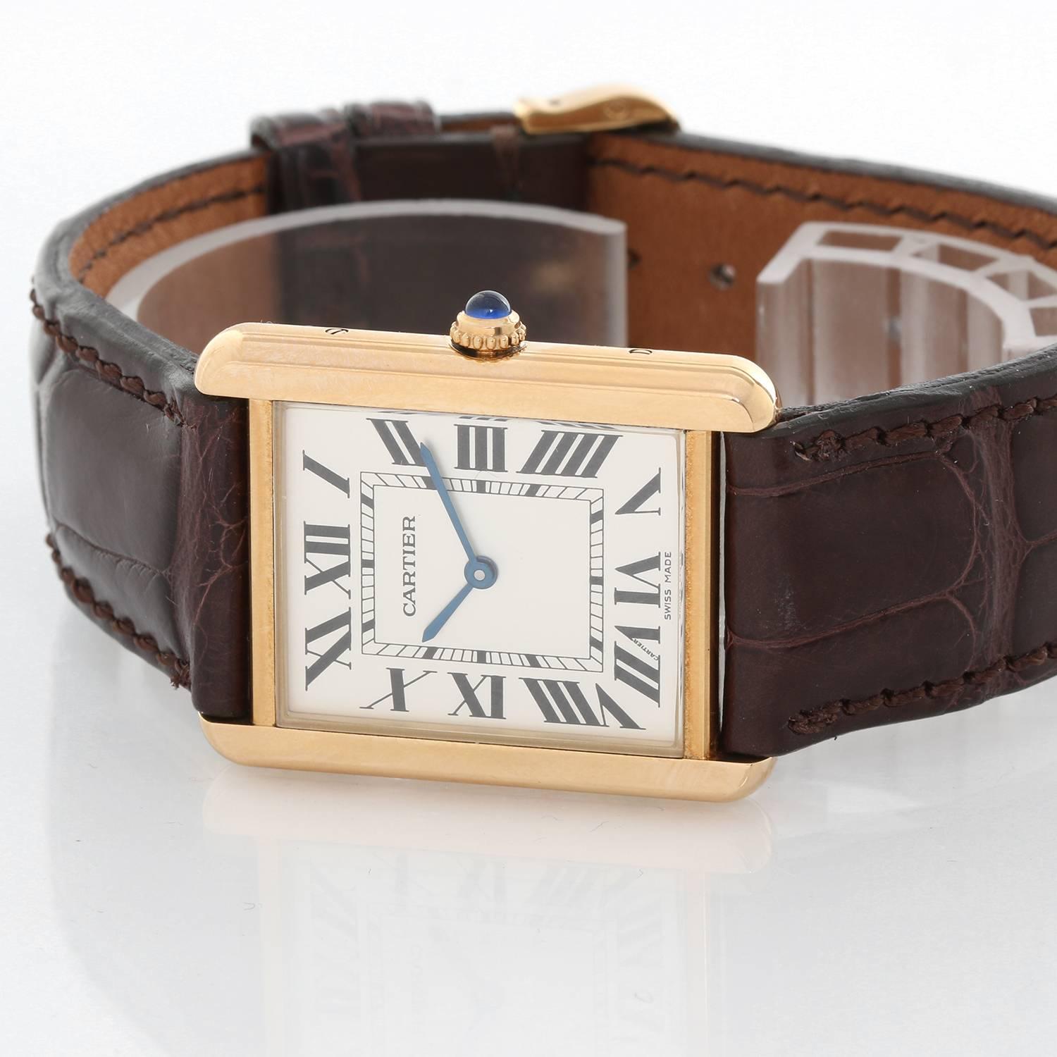 Cartier Tank Solo 18K Yellow Gold Men's Watch W1018855 -  Quartz movement. 18k yellow gold case with stainless steel back (27mm x 34mm). Ivory colored dial with black Roman numerals. Cartier strap band with 18k yellow gold Cartier buckle. Pre-owned