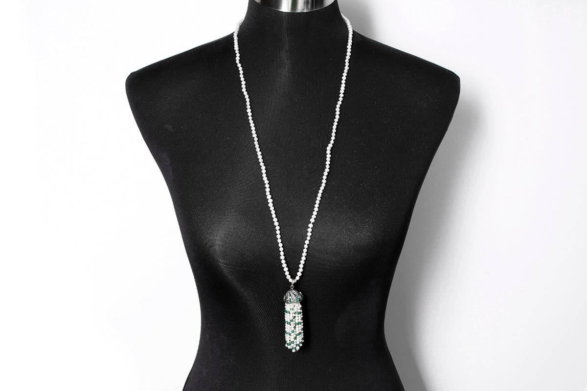 This pearl necklace  features a tassel with emeralds, pearls, and 1.06 carats of diamonds set in  silver. The necklace measures apx. 32-inches and the pendant measures apx. 3-inches in length. Total weight is 42.6 grams.