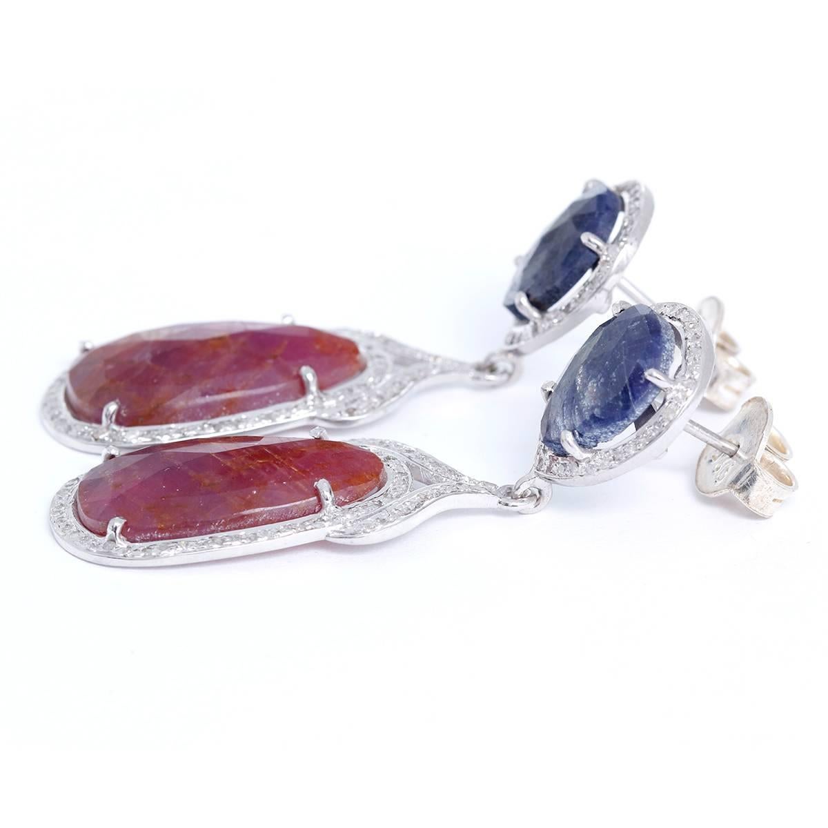  These amazing earrings feature natural sapphires bordered by 1.7 ctw. of diamonds set in sterling silver. Earrings measure apx. 2-inches in length. Total weight is 13.2 grams.