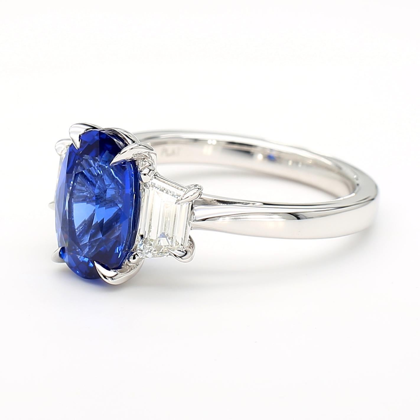 Il bellissimo anello con zaffiro di RareGemworld. Montato in una splendida montatura in platino con uno zaffiro blu naturale dal taglio ovale. Lo zaffiro è circondato da due diamanti bianchi naturali a taglio trapezoidale. Questo anello è destinato