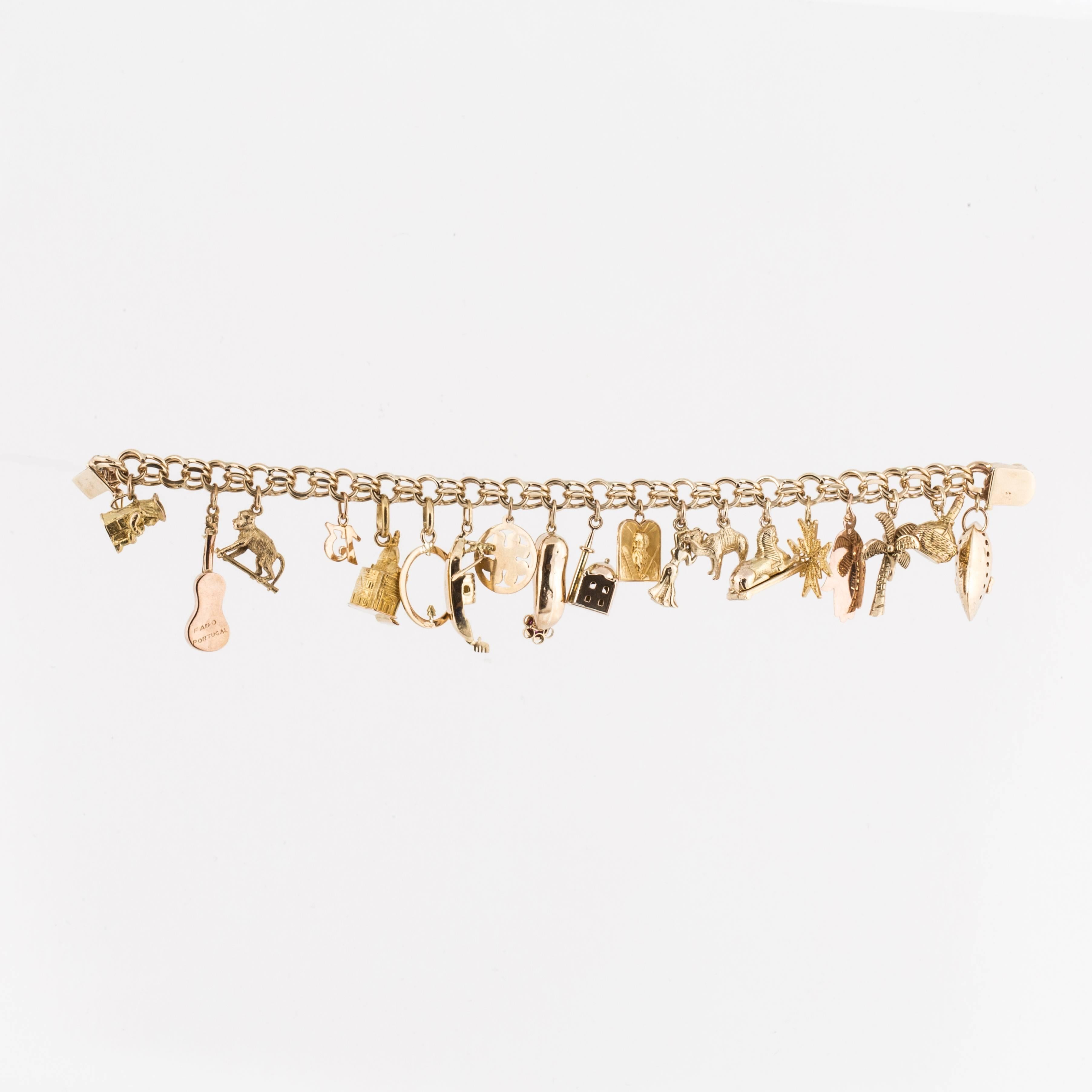 This link bracelet in 14K yellow gold is holding nineteen (19) charms.  The charms are a mixture of 18K, 14K and 9K gold.  Theme seems to be Middle Eastern and European.