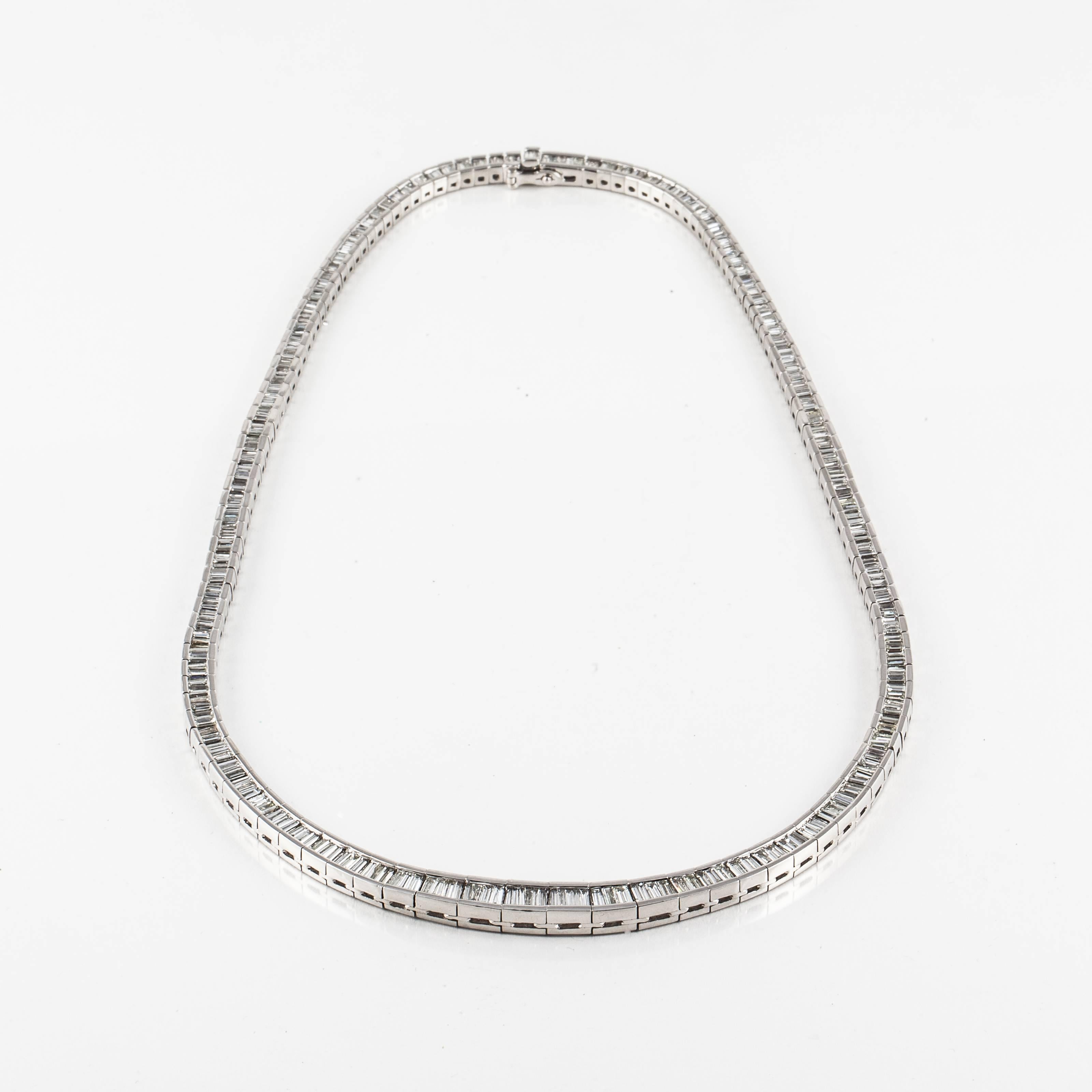 Riviera necklace composed of platinum with baguette diamonds.  The diamonds total 11.12 carats, G-H color and VS-SI clarity.  It measures 16 inches long and 1/4 inches wide at the bottom.  It has a tongue closure and figure eight safety.