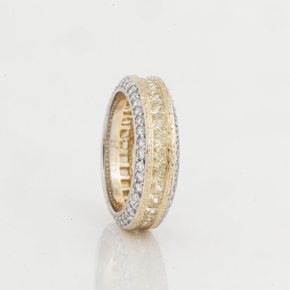 Michael Beaudry platinum and yellow gold diamond band.  Platinum borders set with round diamonds.  The center of the ring has radiant cut yellow diamonds with 18K  yellow gold bordering each side.  There are 29 fancy yellow radiant cut diamonds for
