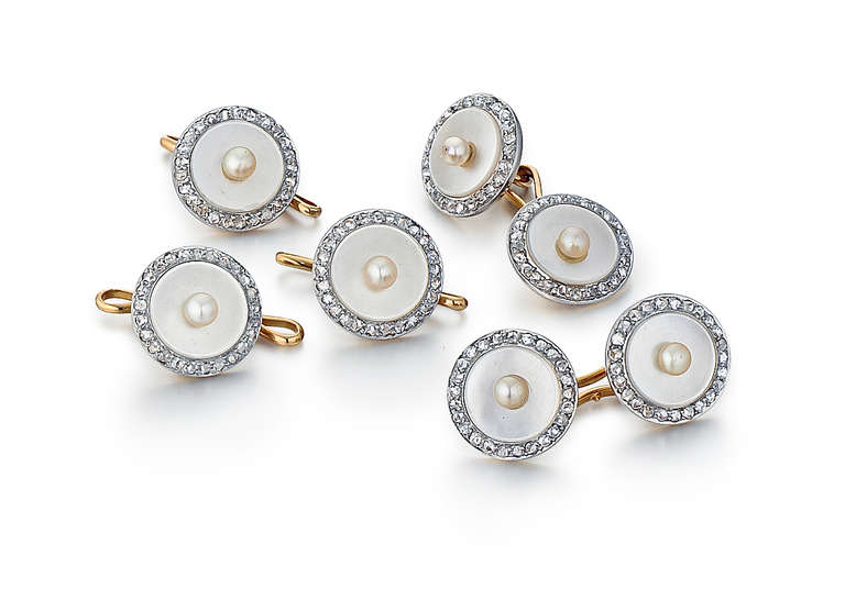 This mens' dress set is comprised of two cufflinks and three shirt studs. They are made of both 14k yellow gold and platinum, with mother-of-pearl, diamonds, and seed pearls. There are 1.23 carats total weight of diamonds, and 7 seed pearls