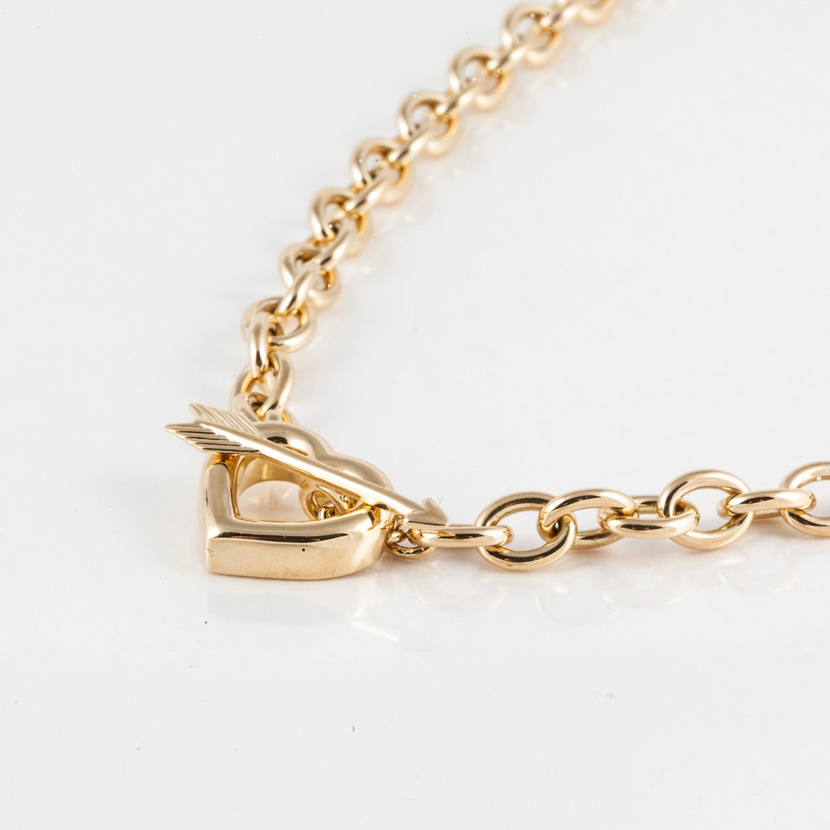 Tiffany & Co. link necklace is 18K yellow gold and features a heart with arrow as the toggle closure. Fully hallmarked on back of heart.  The necklace measures 16 1/2 inches in length.