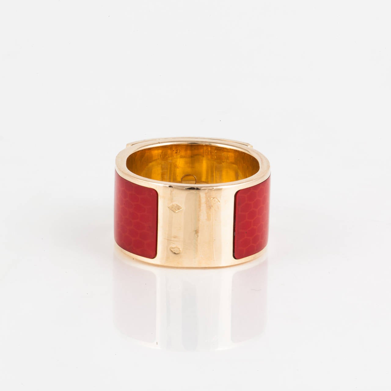 This ring by Hermes is from the Collier De Chien collection.  It features red enamel on 18K yellow gold. The inside of the band is marked 