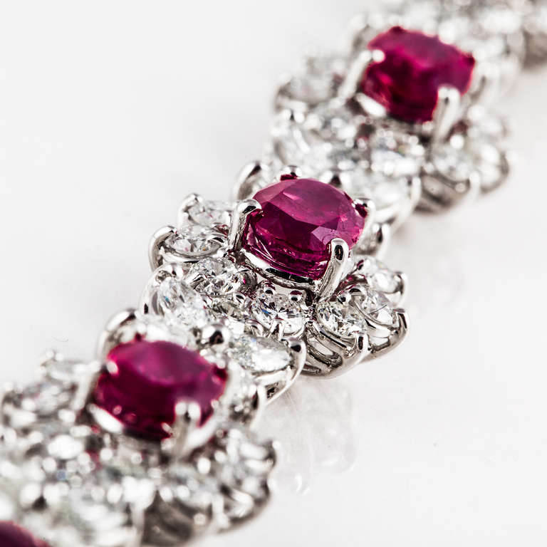 Platinum necklace with a floral design featuring seven oval-shaped rubies (heat treated) that weigh approximately 10.50 carats total weight.  The round and marquise diamonds total 11.38 carats; G-I color and VS1-SI1 clarity.  The necklace measures