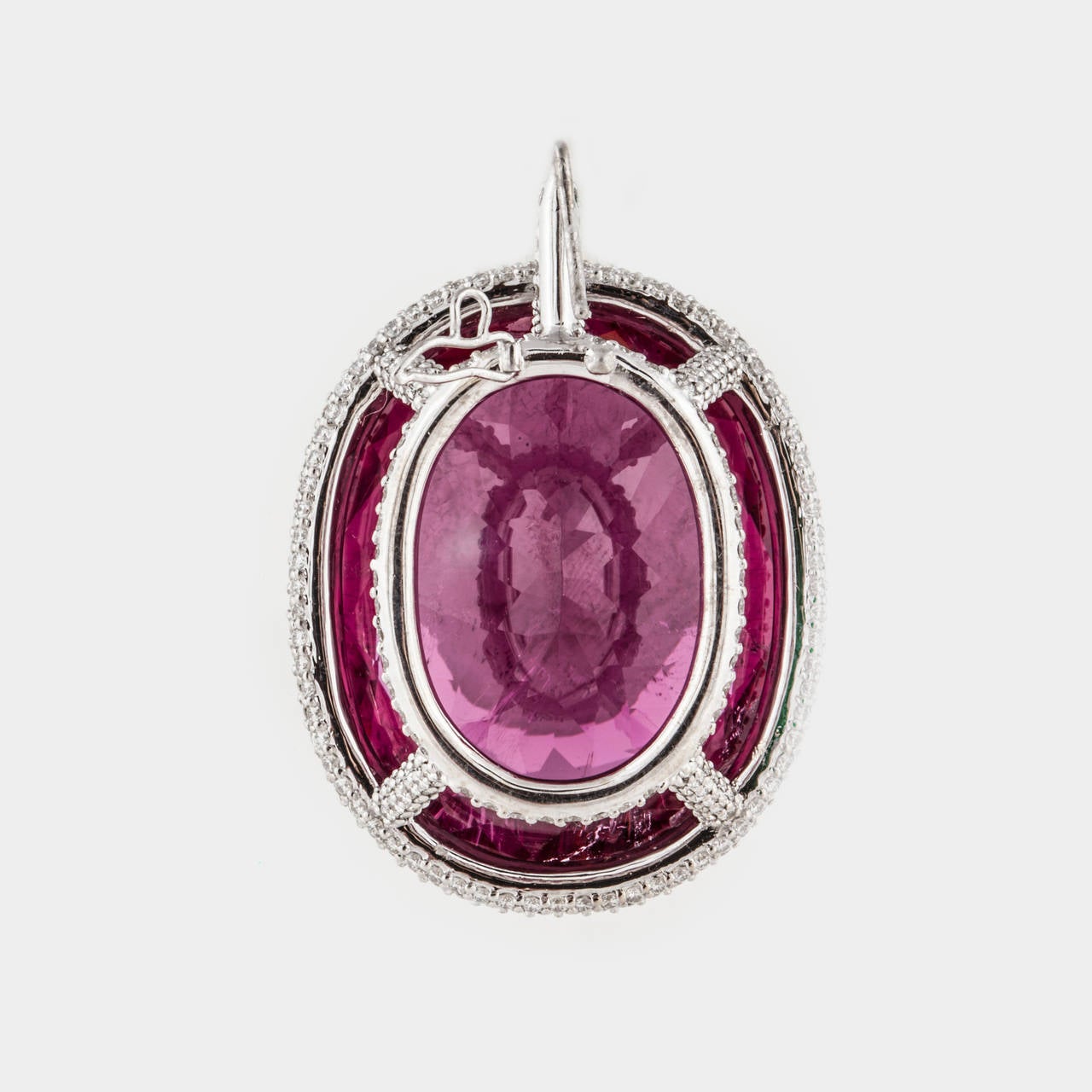 Pendant composed of 18K white gold featuring a spectacular 53.28 carat oval shaped rubellite framed by 357 round diamonds.  The diamonds total 2.90 carats; G-H color and VS1-VS2 clarity.   Measures 1 3/16 inches long, 7/8 inches wide and 1/2 inch