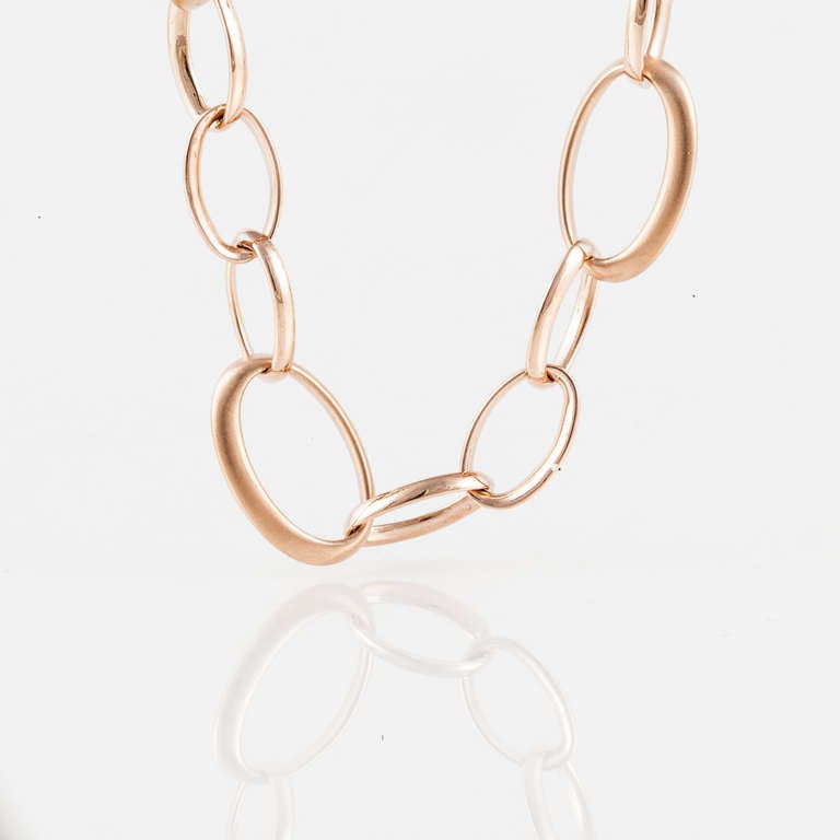 Estate Crivelli long necklace in 18K rose gold featuring solid oval links of varying sizes.  The clasp features two round diamonds that weigh a total of 0.15 carats.  The necklace measures 36 inches in length, but could be shortened and worn as a