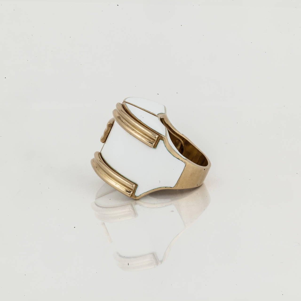 This vintage dome style ring by David Webb is composed of 18K yellow gold with white enamel.  It is marked 