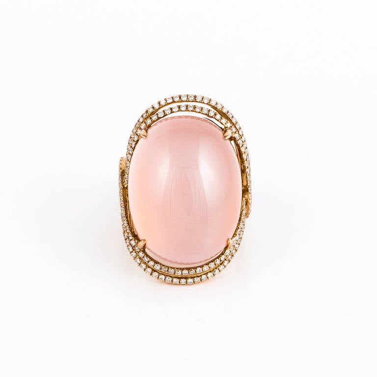 18K rose gold ring featuring a 40.75 carat cabochon rose quartz framed by a double row of round diamonds that criss cross down the sides.  The diamonds total 1.40 carats.   Ring is currently a size 7 and may be sized.