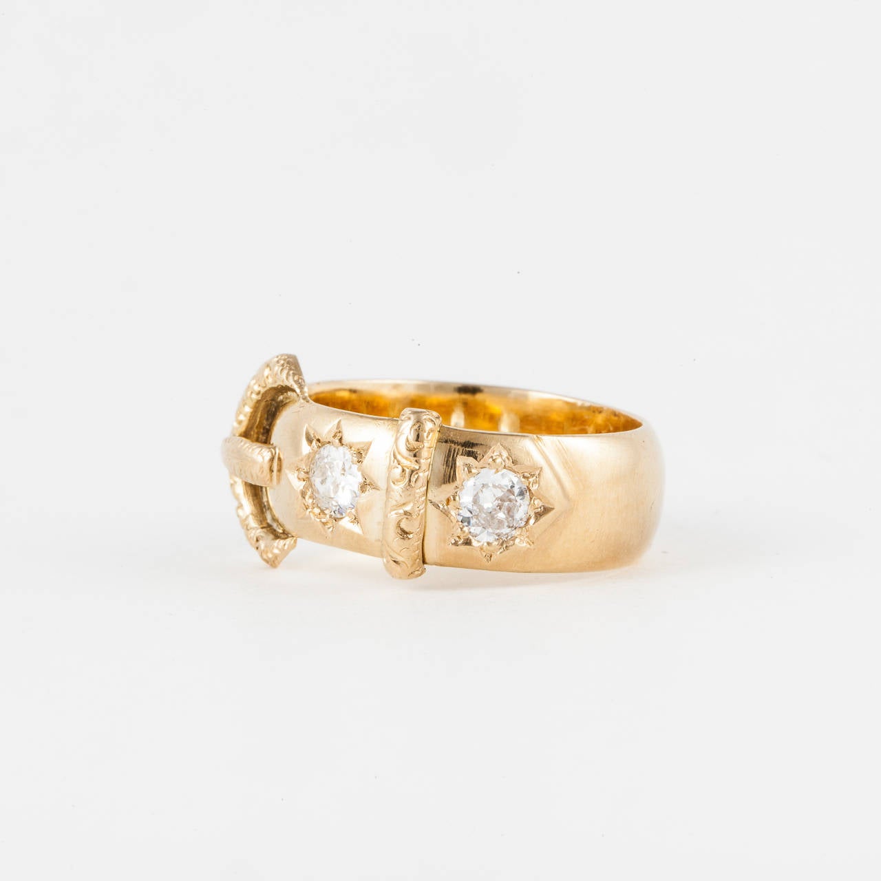 18K yellow gold buckle ring with hallmarks indicating ring was made in London in 1917.  Features two (2) Old Mine cut diamonds with a total weight of 0.75 carats. Beautiful engraving with diamonds set inside a star pattern.  Measures 3/8 of an inch