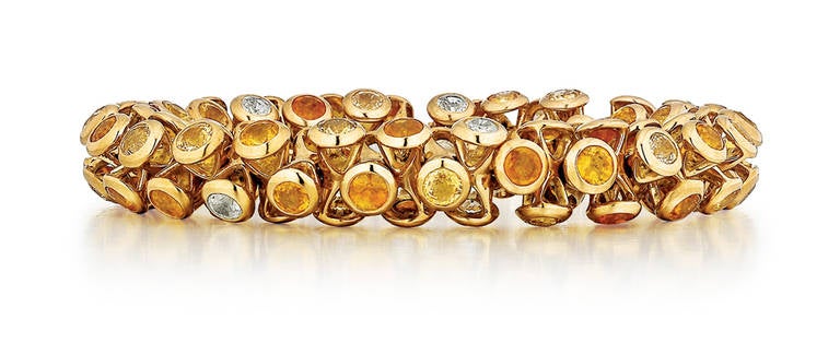 Bracelet composed of varying shades of round yellow sapphires totaling 75 carats, bezel set in 18K yellow gold. 