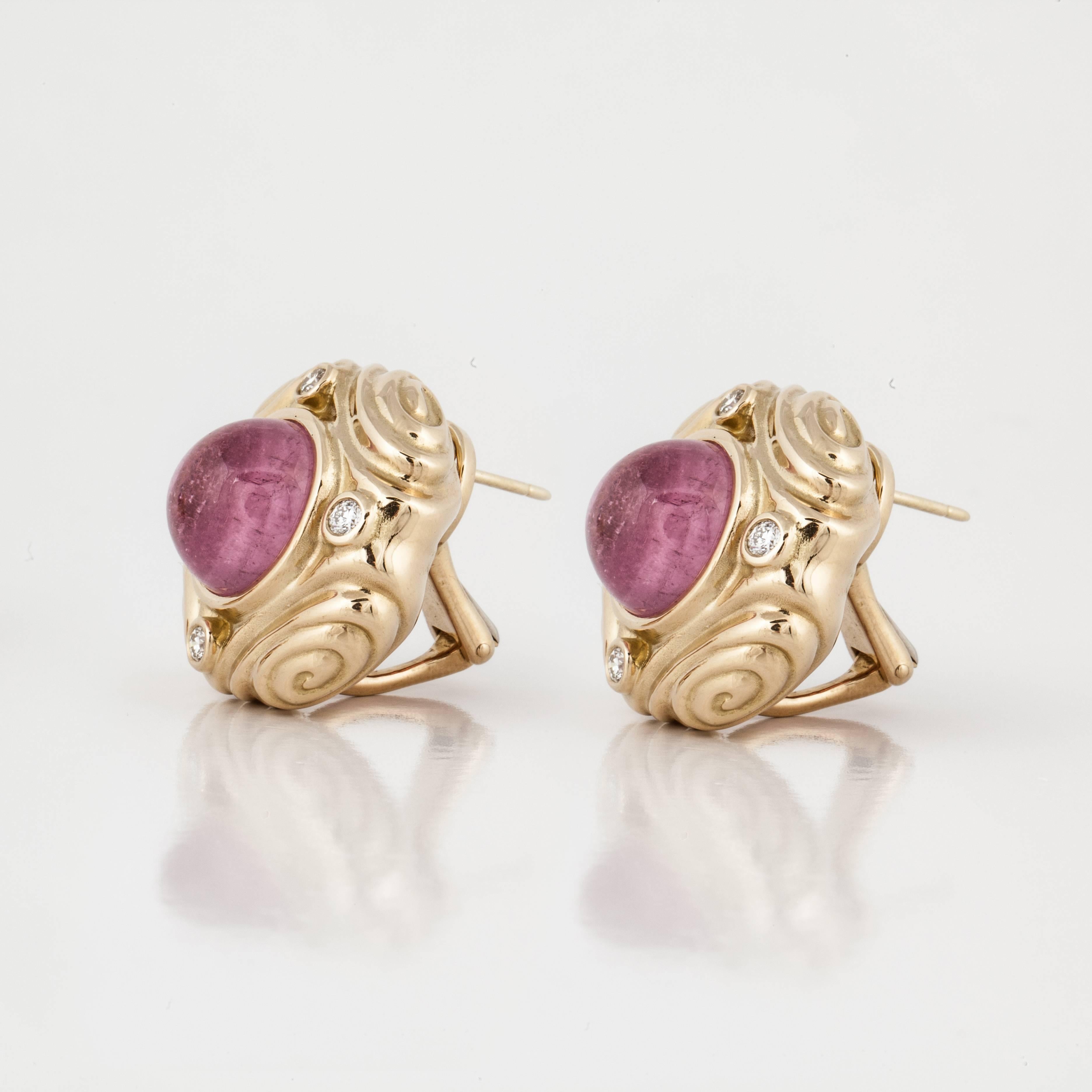 18K yellow gold button style earrings featuring cabochon pink tourmaline stones accented by round diamonds. There are eight round diamonds that total 0.60 carats. The earrings measure 7/8 inches wide, and have omega backs with posts.  They are