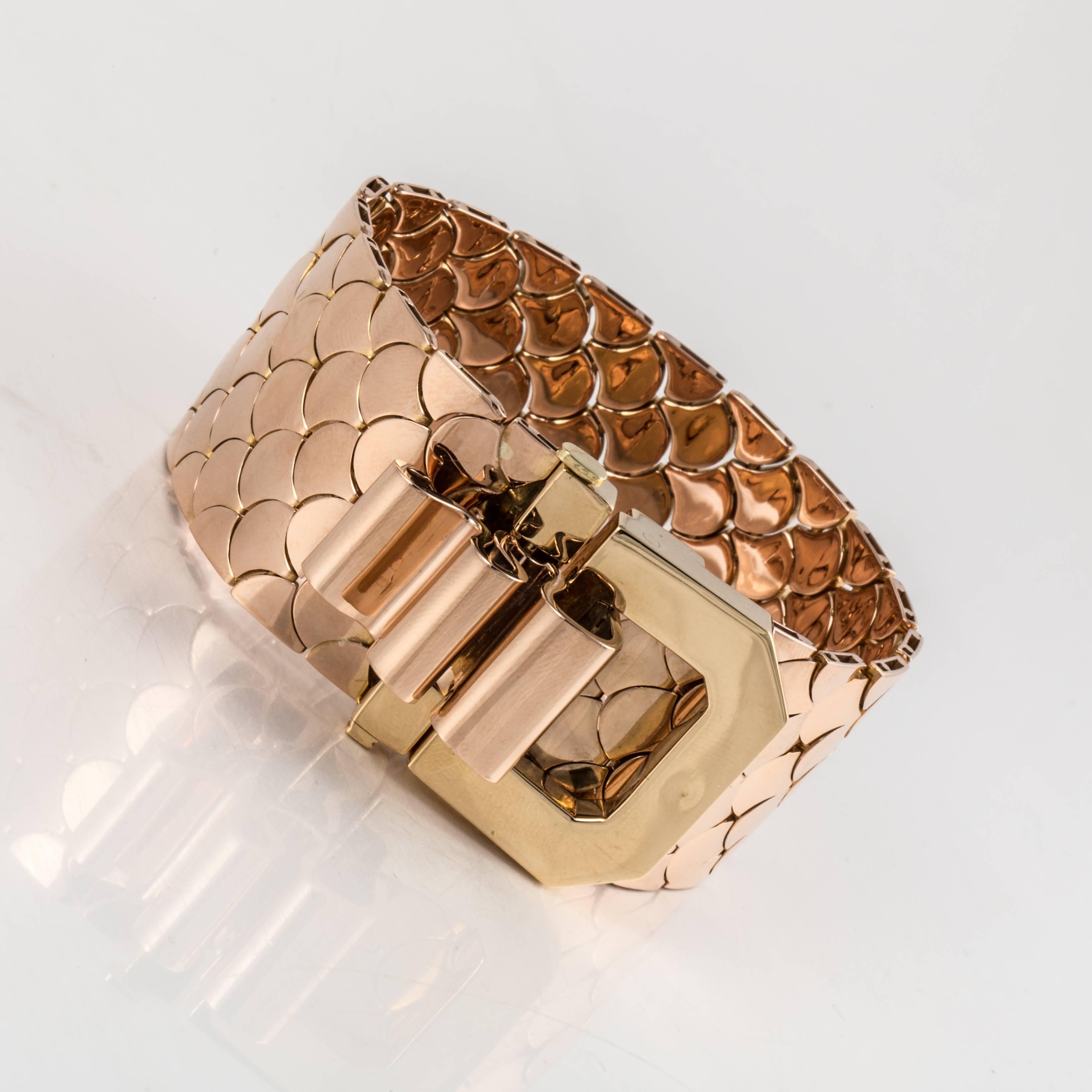 18K rose gold French bracelet. Features a scale design with a large buckle style closure. Measures 7 1/16 inches long and 1-1/8 inches wide. The buckle stands 1-1/16 inches tall.  