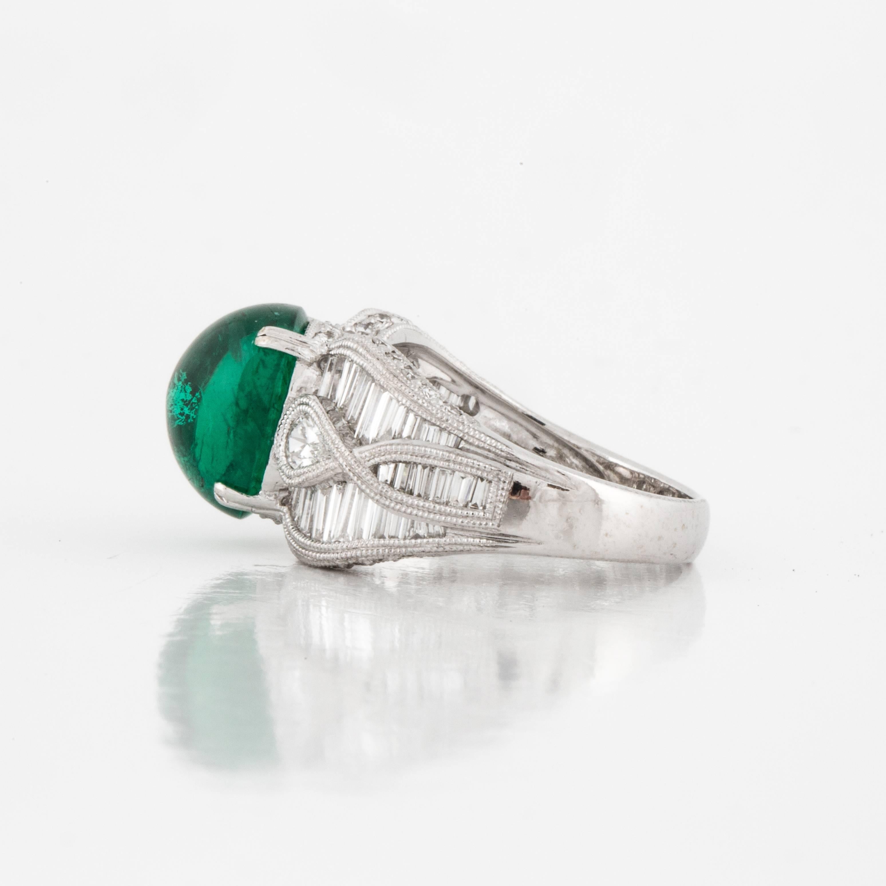 18K white gold ring featuring a 4.65 carat cabochon emerald accented by round, pear, and baguette diamonds.  There are forty-eight baguette diamonds that total 1.60 carats, two pear-shaped diamonds that total 0.25 carats and thirty-four round