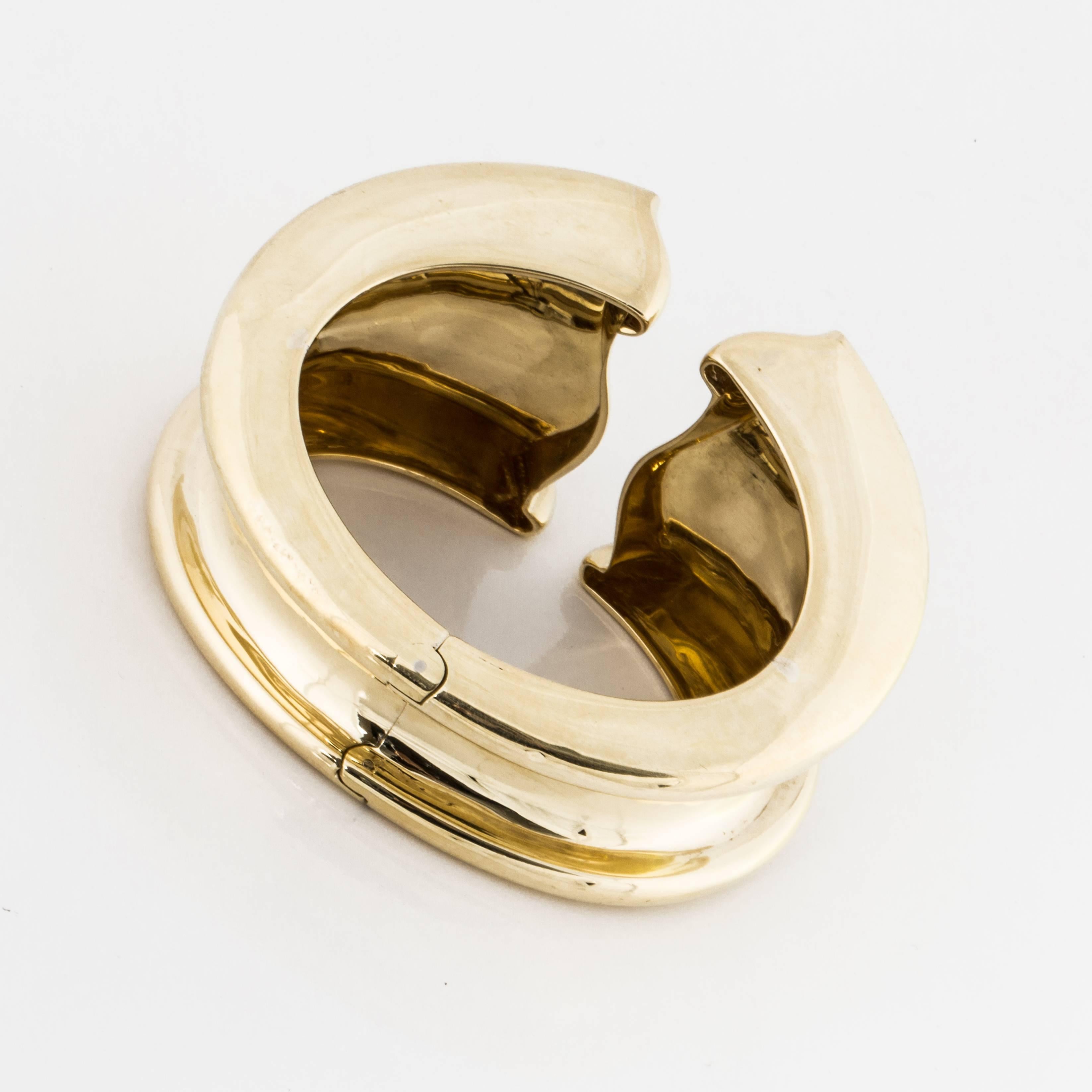 Hinged bangle in a free form and open design.  The top measures 1 7/8 inches at the widest point and 7/8 inches at the bottom (hinged area).  When the bangle is closed the opening measures 2 3/8 inches.  