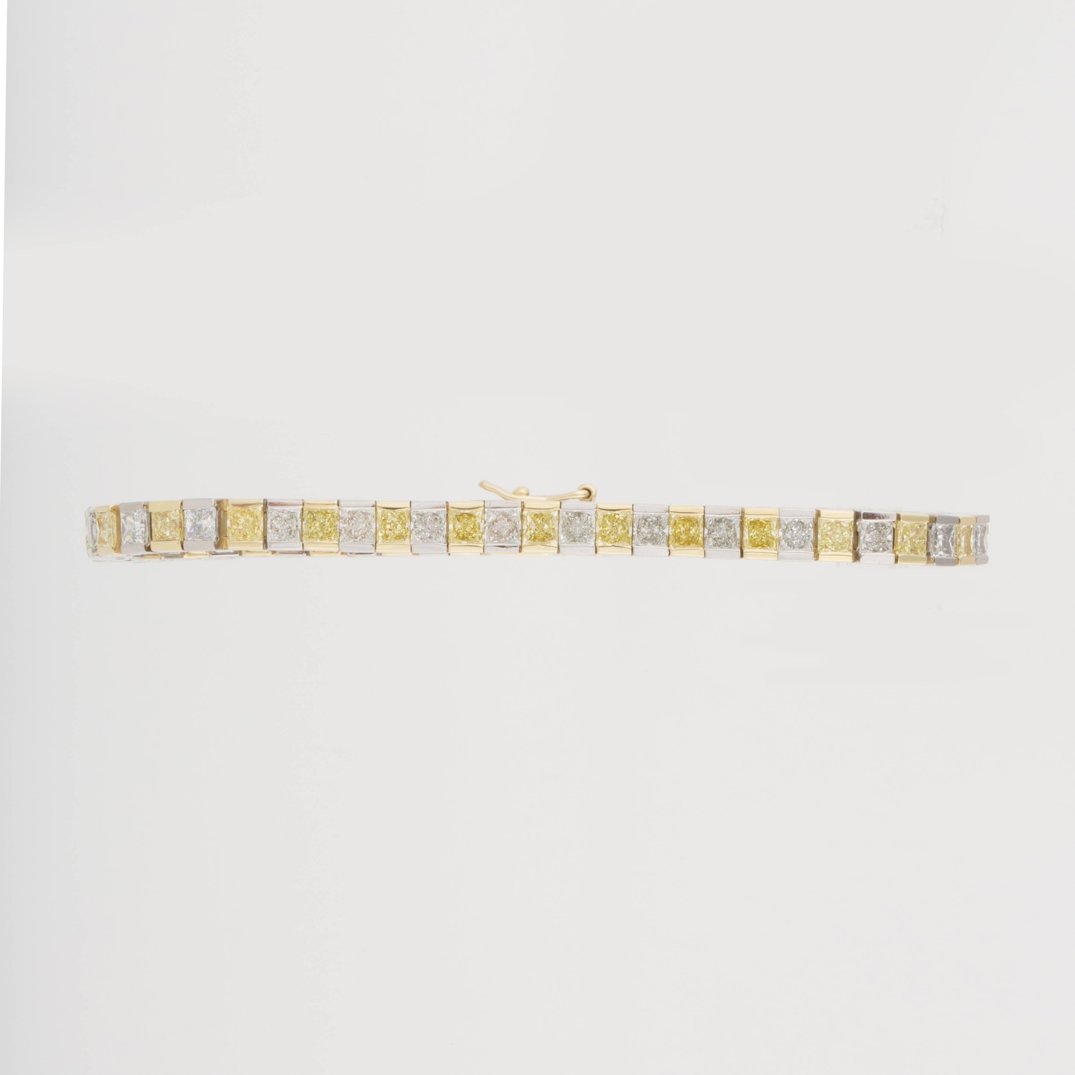 Classic line bracelet composed of platinum and 18K yellow gold featuring alternating white and yellow princess-cut diamonds.  There are 28 diamonds that total 5.10 carats,  fancy yellow to fancy intense yellow, and VVS1-SI1 clarity.  Additionally