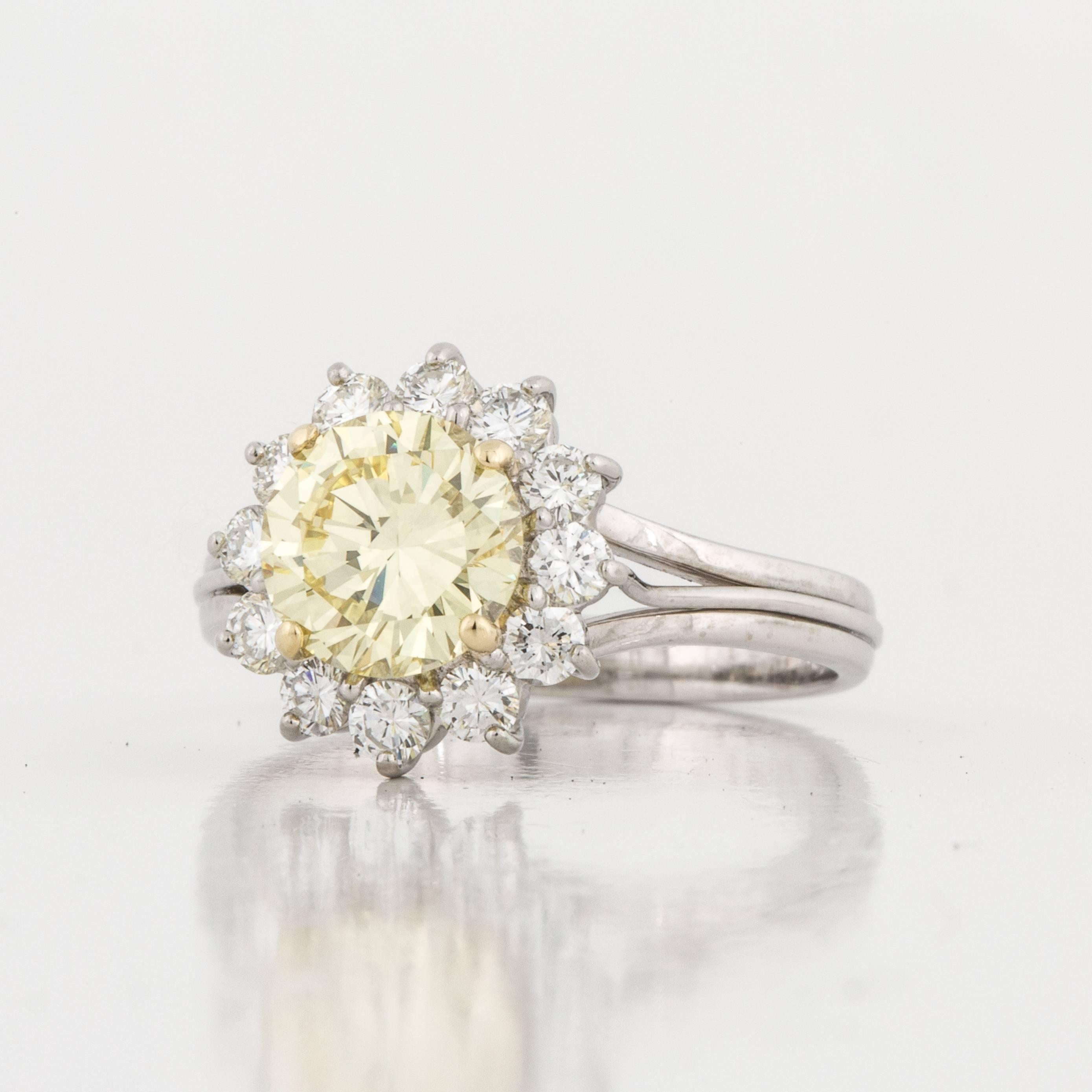 Tiffany & Co. ring composed of platinum featuring a fancy intense yellow diamond surrounded by white diamonds.  The ring is marked 