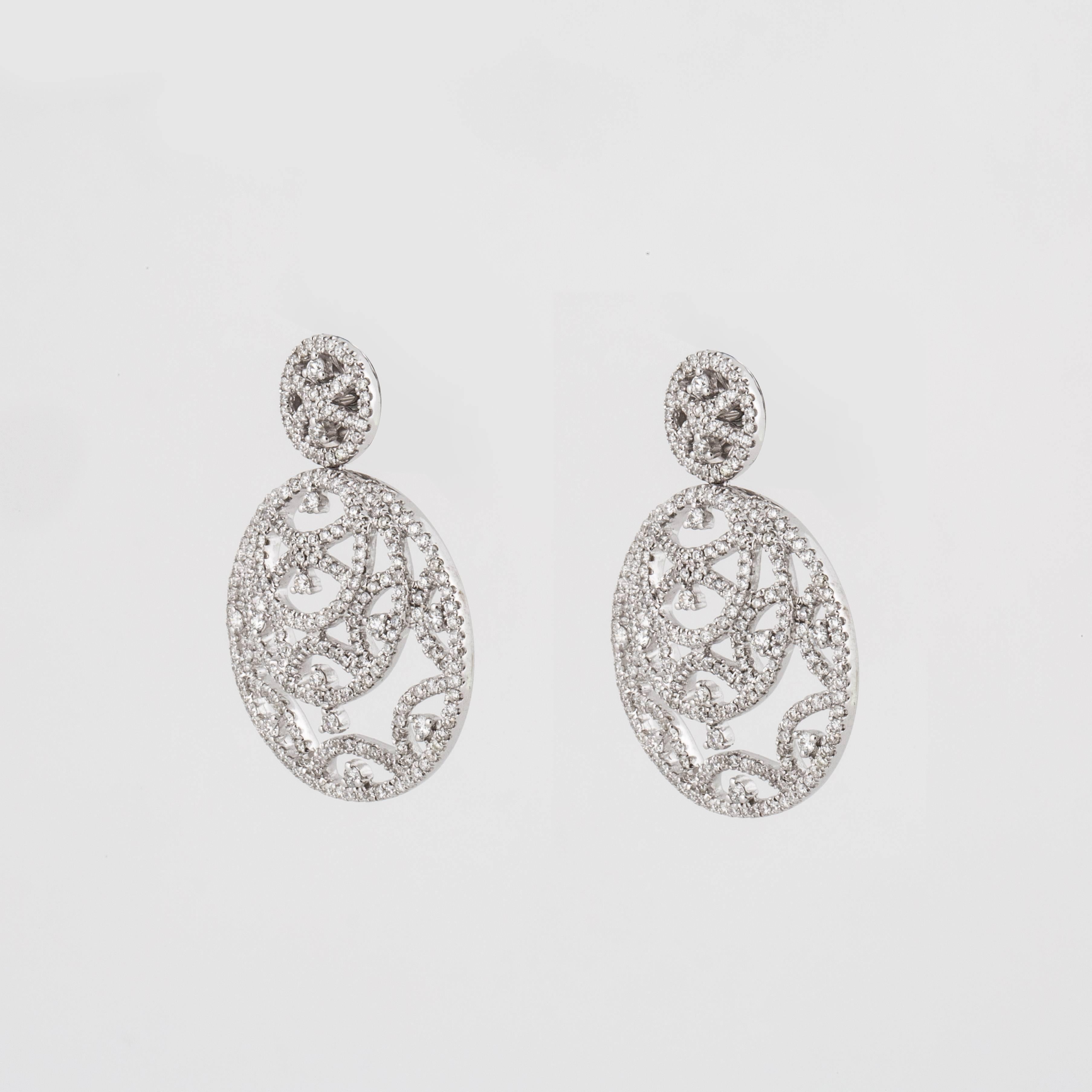 Openwork diamond earrings composed of 18K white gold.  The openwork circles are encrusted with 526 round diamonds that total 2.45 carats, G-I color and VS2-SI2 clarity.  They measure 1 3/16 inches long and 7/8 inches wide.  They are for pierced ears