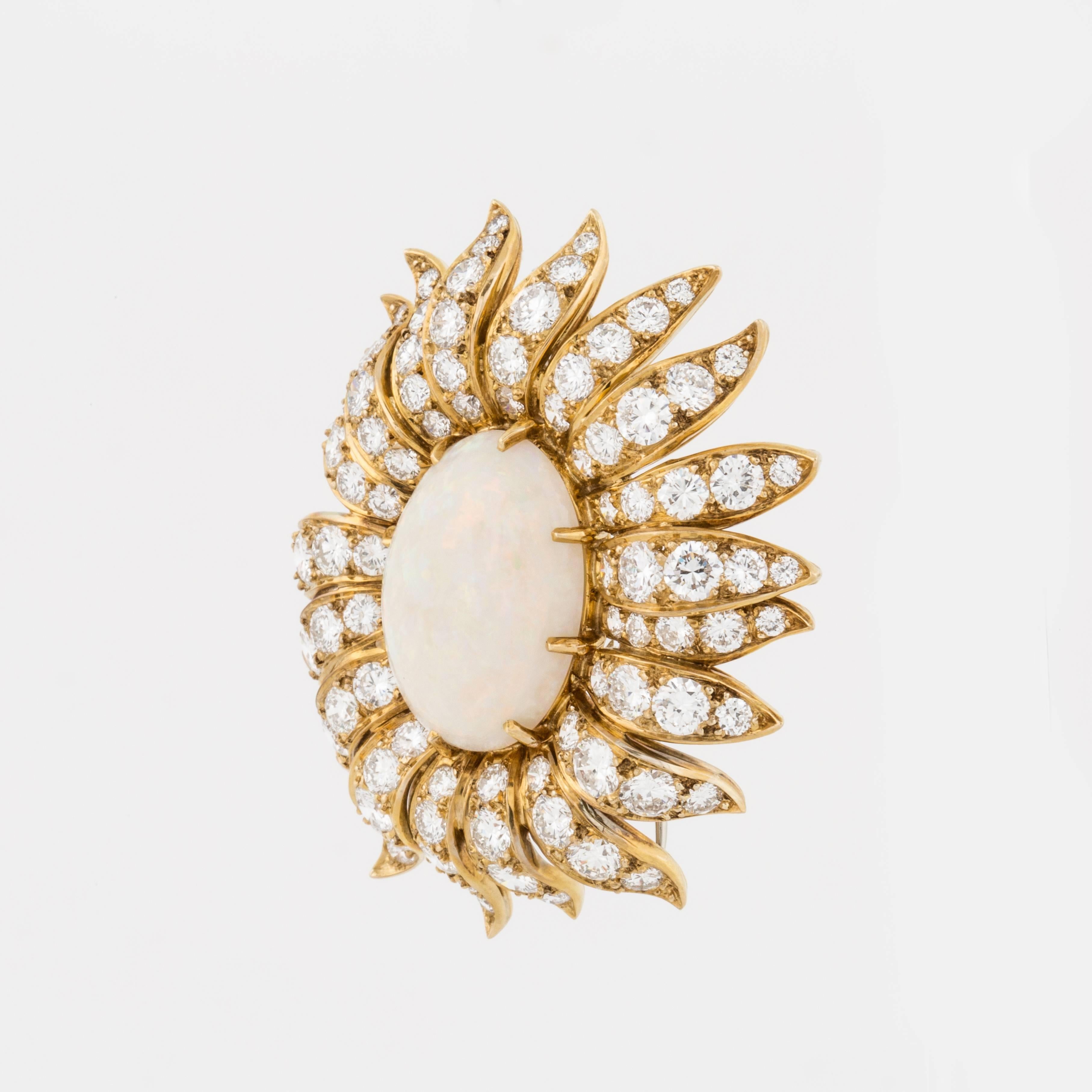 Cartier flower brooch clip is composed of 18K yellow gold featuring an opal framed by round brilliant-cut diamonds.  The clip is marked 