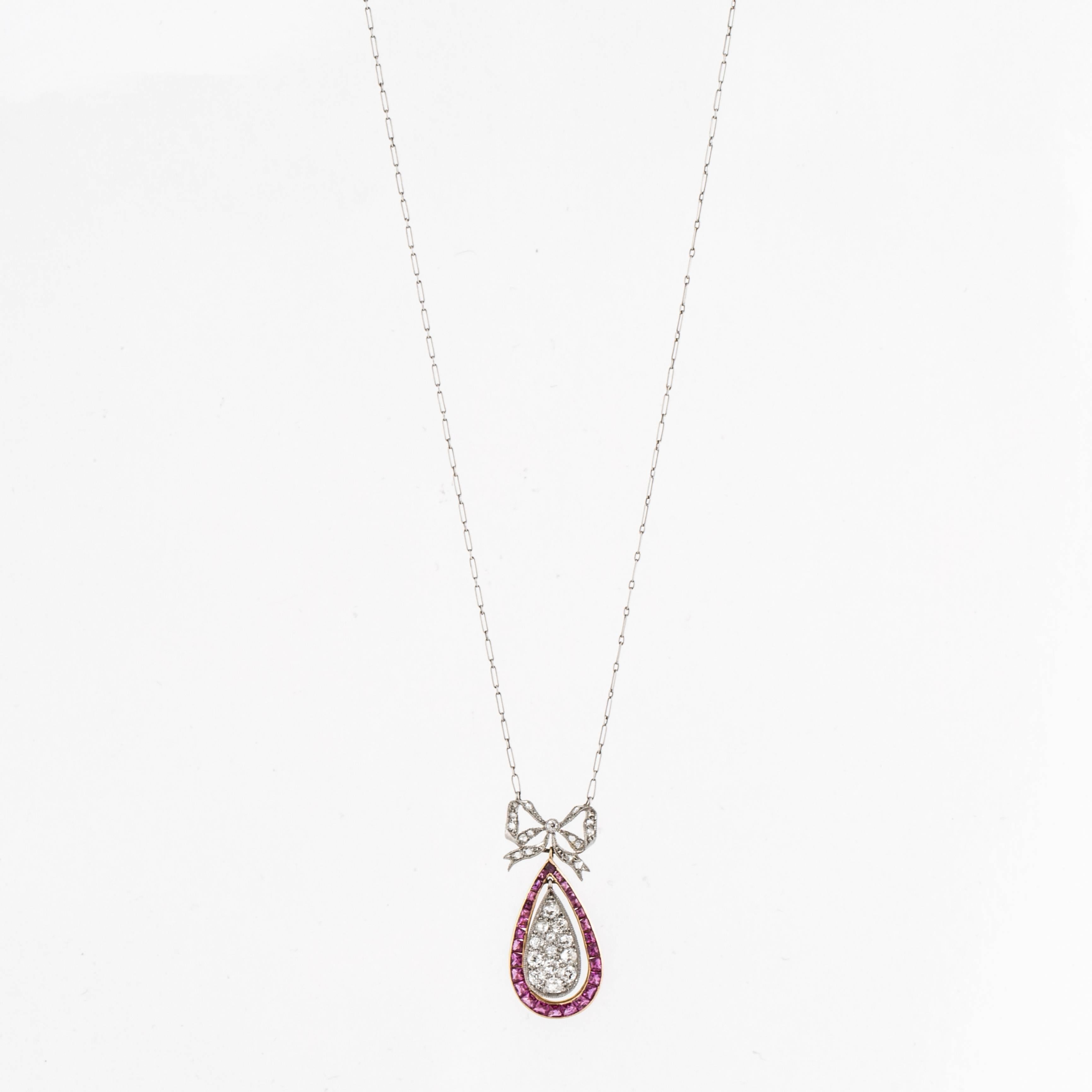 Belle Epoque platinum and 18K gold bead set diamond and calibré-cut ruby pendant necklace with French marks circa 1910.  There are 14 rose cut diamonds that total 0.14 carats and 14 single-cut diamonds that total 0.53 carats.  The diamonds are G-J
