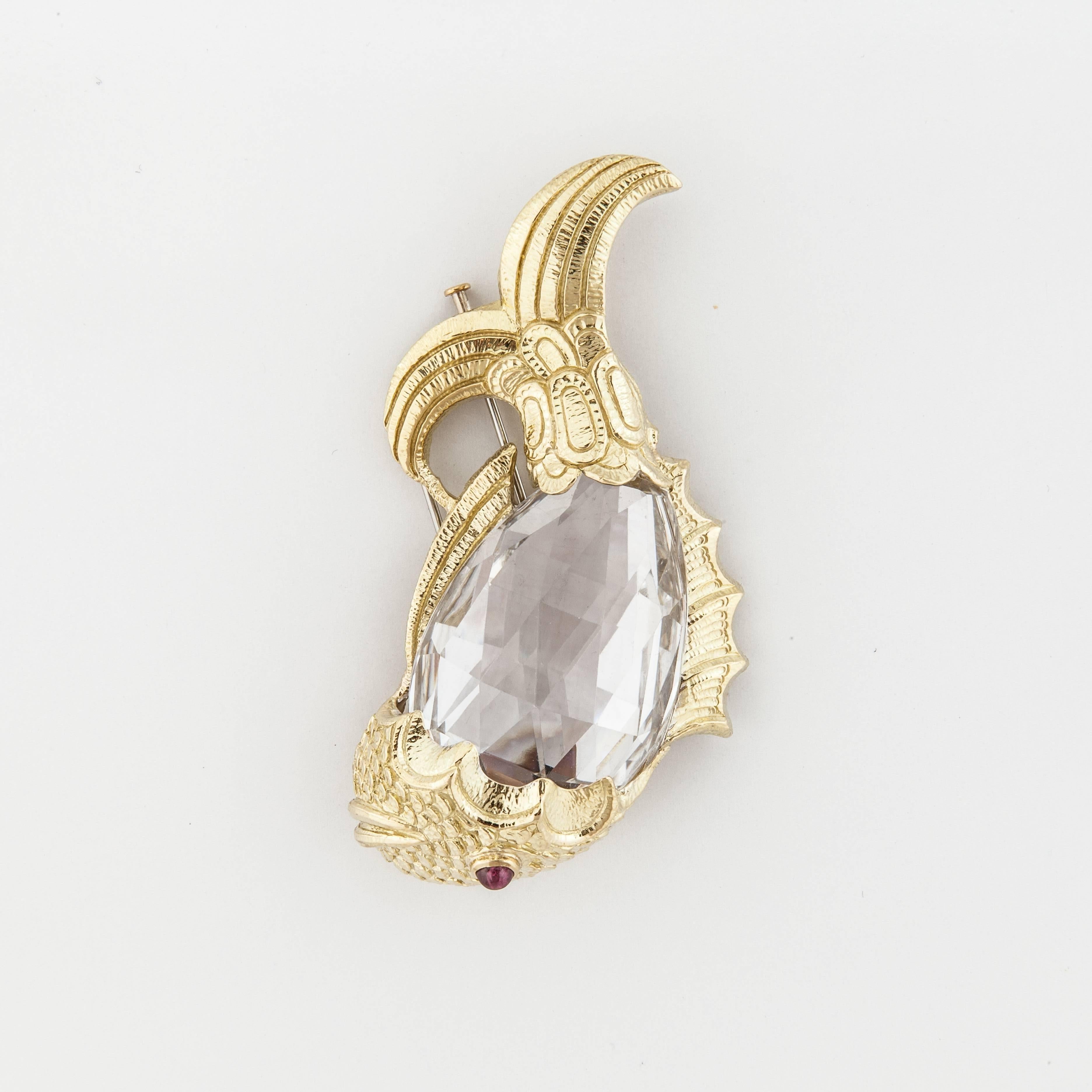 David Webb large fish brooch composed of 18K yellow gold with a carved rock crystal body, and a round cabochon ruby eye.  Marked on the back 