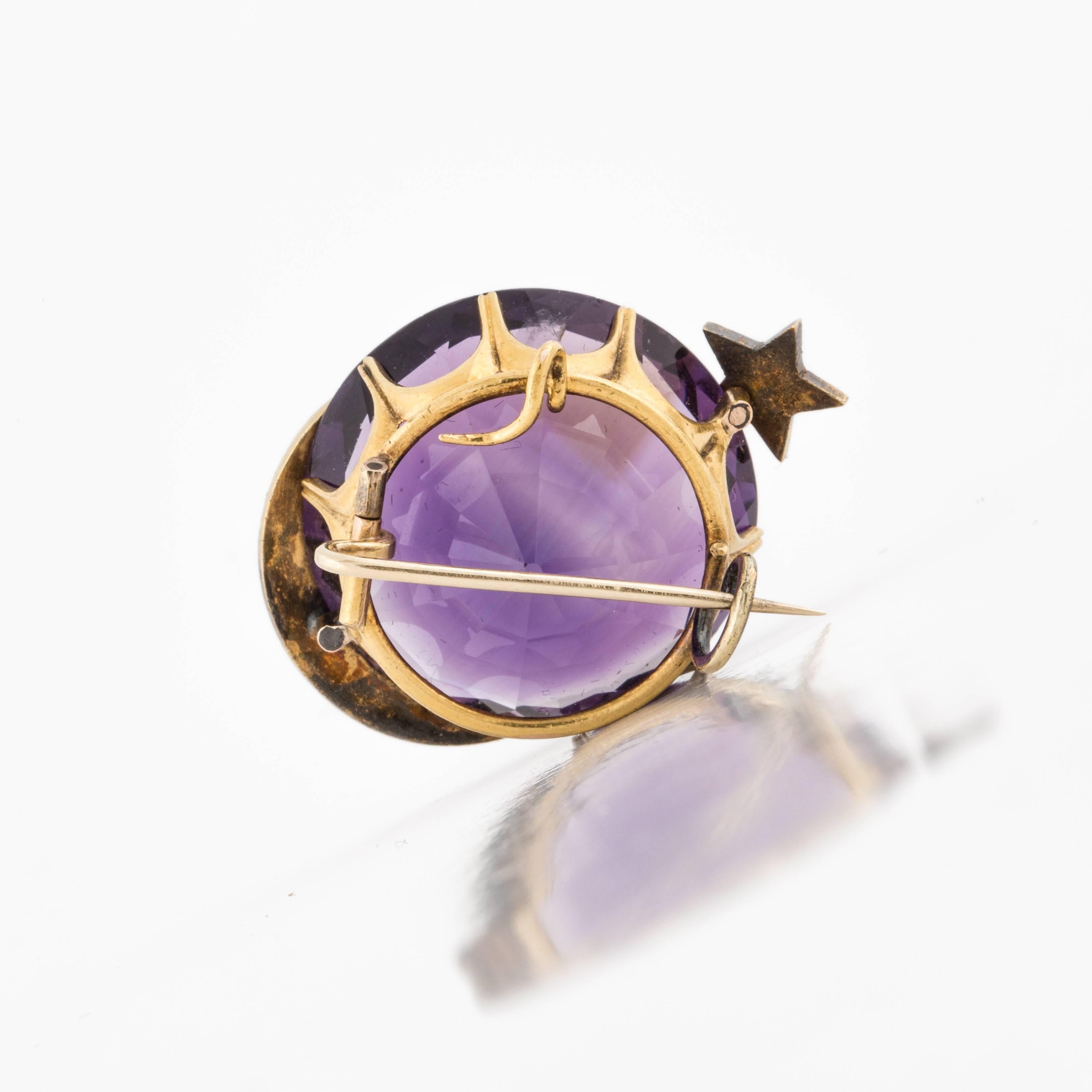 Antique watch pin in 15K yellow gold featuring a 40carat amethyst in the center.  The moon and star is represented in split pearls.  Stone is set in a crown mounting and the clasp has no safety.  Measures 1 3/8 inches across and it stands 1/2 inch