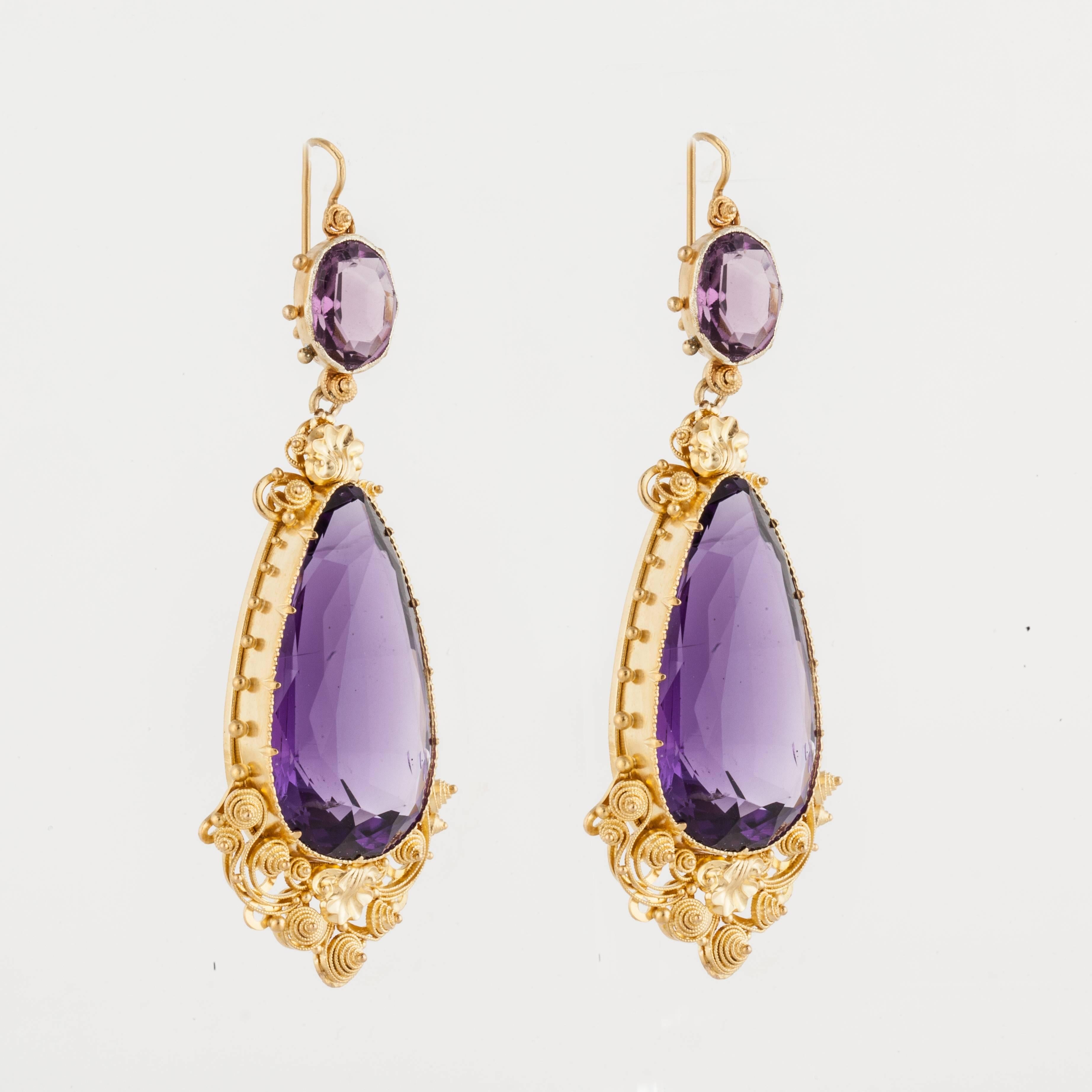 Antique drop earrings crafted in 22K yellow gold featuring oval and pear-shaped amethysts that total 79 carats.  The Etruscan gold work is fine and detailed.  The earrings measure 2 3/4 inches long and 1 inch wide at the bottom.  These are for