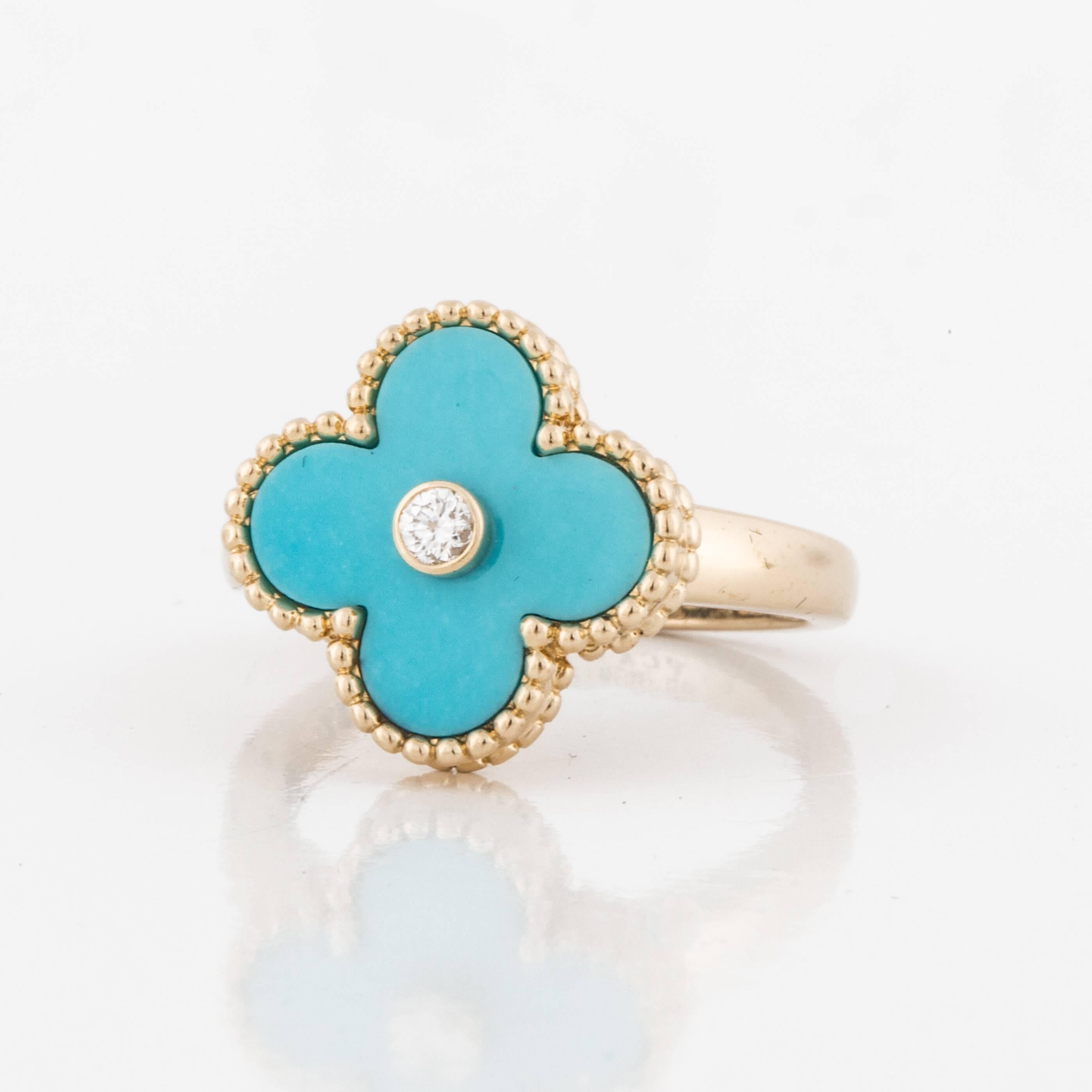 Yellow gold ring marked "VCA G750 52 JBO91205" on the inside. From the Alhambra series, this ring features a carved turquoise stone with a diamond in the center.  The diamond is .06 carats and it is D-F in color and VVS1 in clarity.