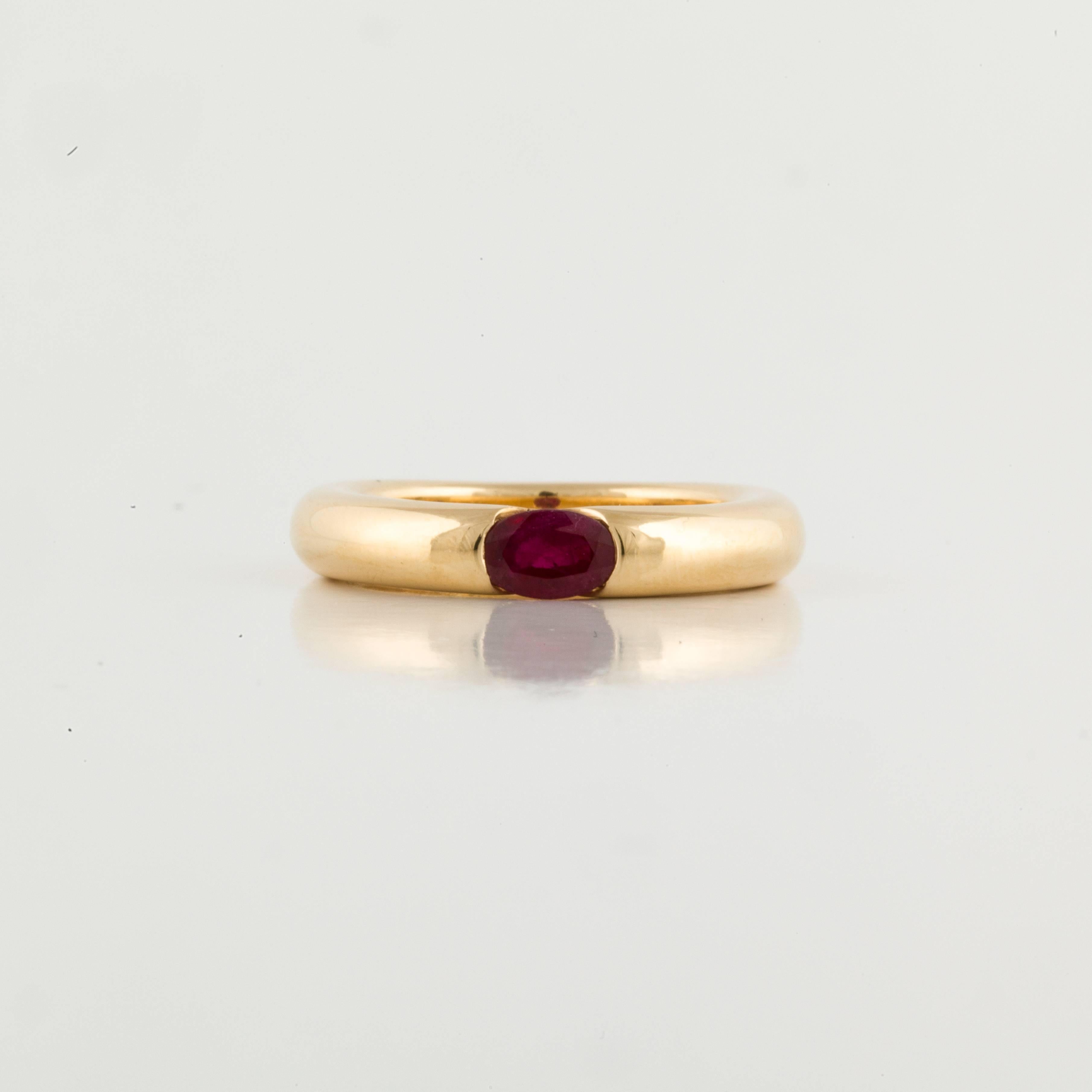Cartier Ellipse ring in 18K yellow gold featuring an oval faceted ruby. The ring is marked 
