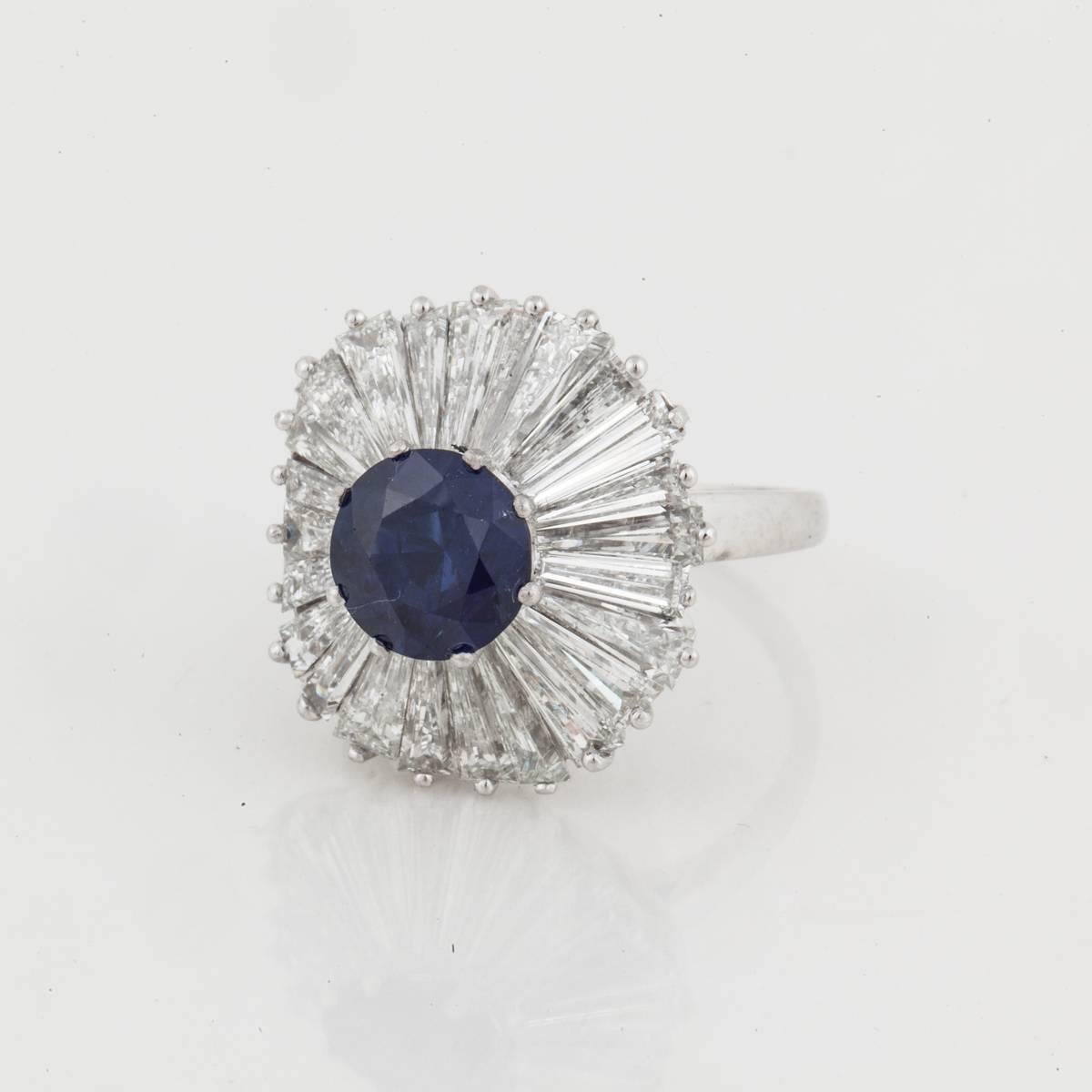 Platinum ballerina ring featuring a 2.47 carat blue sapphire and baguette-cut diamonds.  The sapphire is accompanied by an AGL report, stating Burma, no heat.  The diamonds total 10 carats, F-G color, and VVS-VS clarity.  The ring is a size 7 and