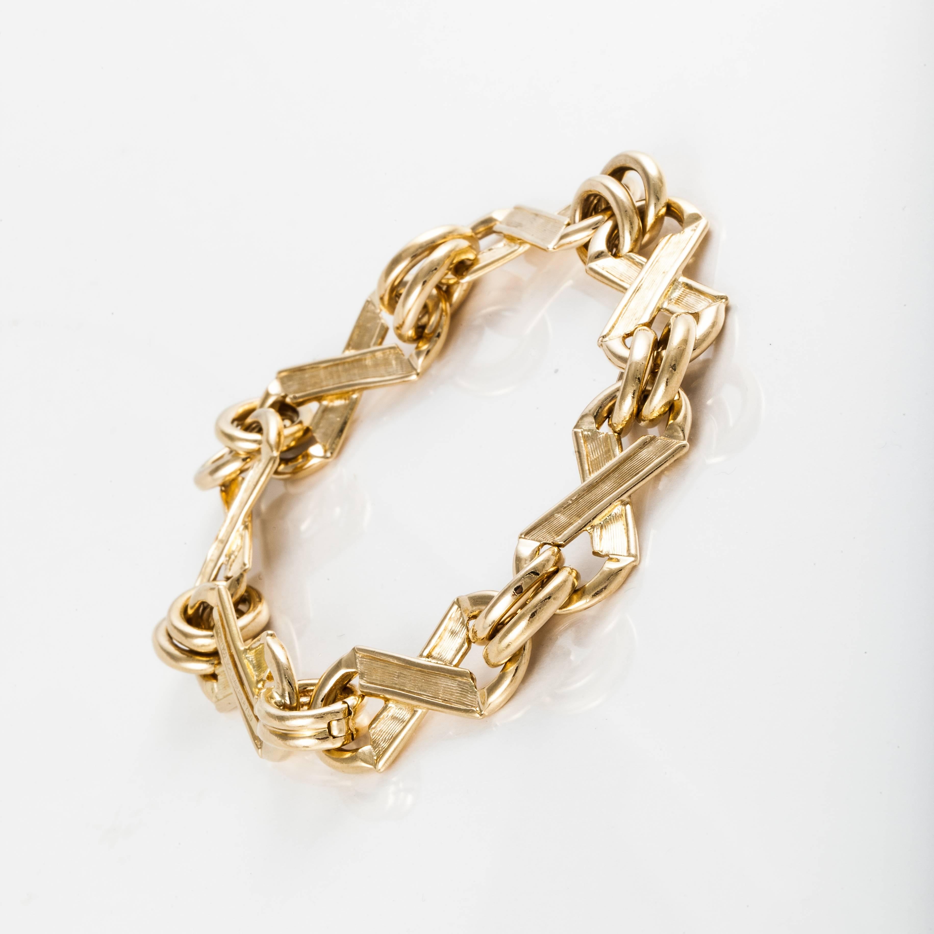 Classic bracelet by Tiffany & Co. Schlumberger in 18K yellow gold with X's and O's in both a brushed and high polish finish.  The bracelet is marked 