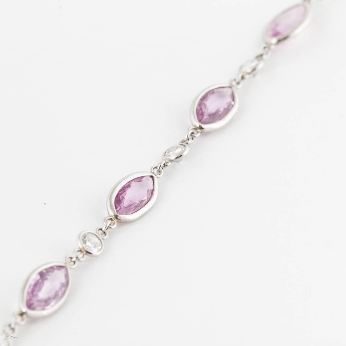 Platinum sapphire and diamond by the yard style chain necklace featuring 49 marquise-shaped pink sapphires and 49 round diamonds.  The sapphires and diamonds are in an alternating pattern.  The sapphires total 33.90 carats and the diamonds total