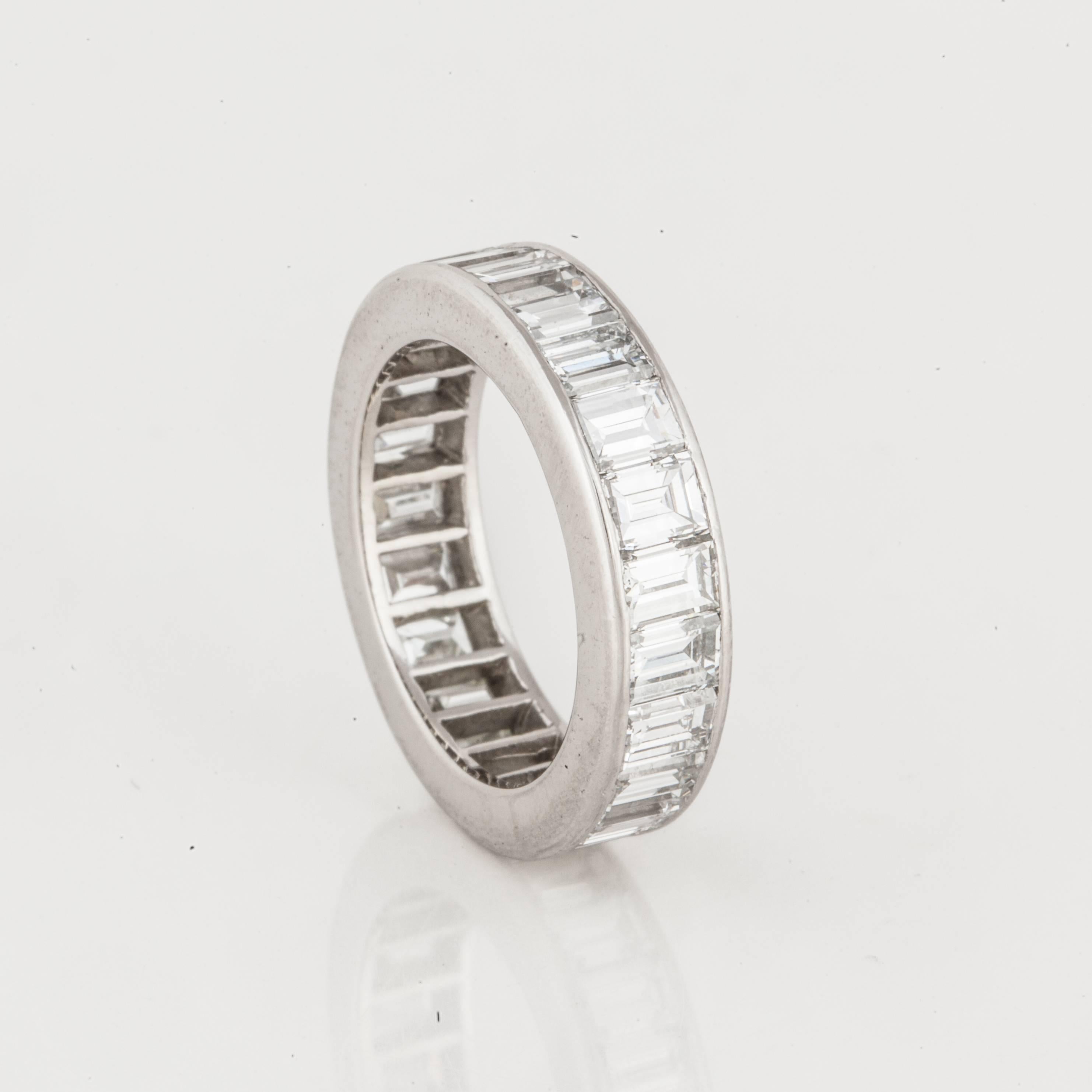 Platinum eternity band featuring emerald-cut diamonds.  There are 23 emerald-cut diamonds totaling 4.60 carats, G-H color and VVS2-VS1 clarity.  Ring is a size 6. It measures 5 mm wide and is 3 mm thick. 