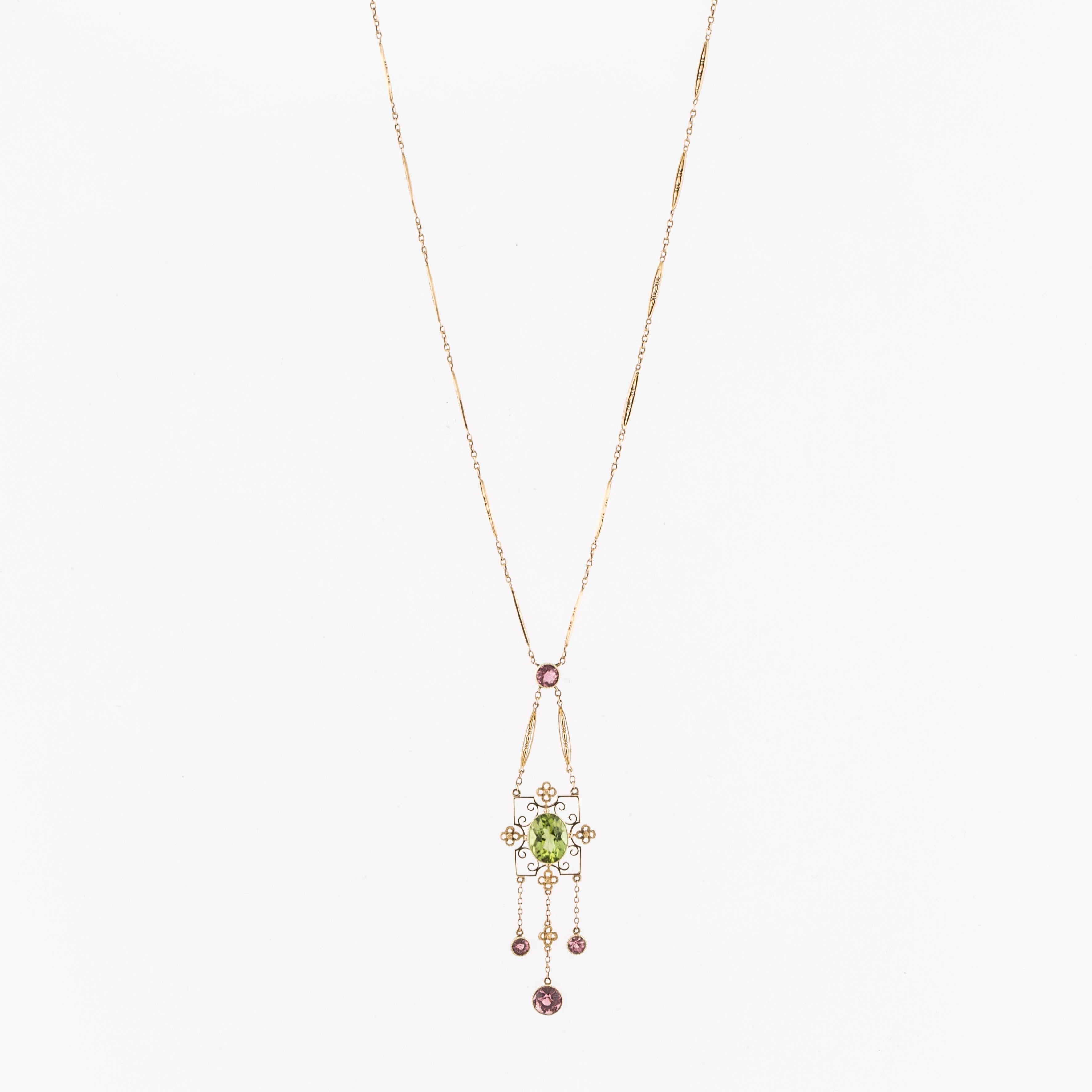 Gorgeous yellow gold lavalier set in 15K.  Features an oval peridot and pink tourmalines.  Necklace measures 22