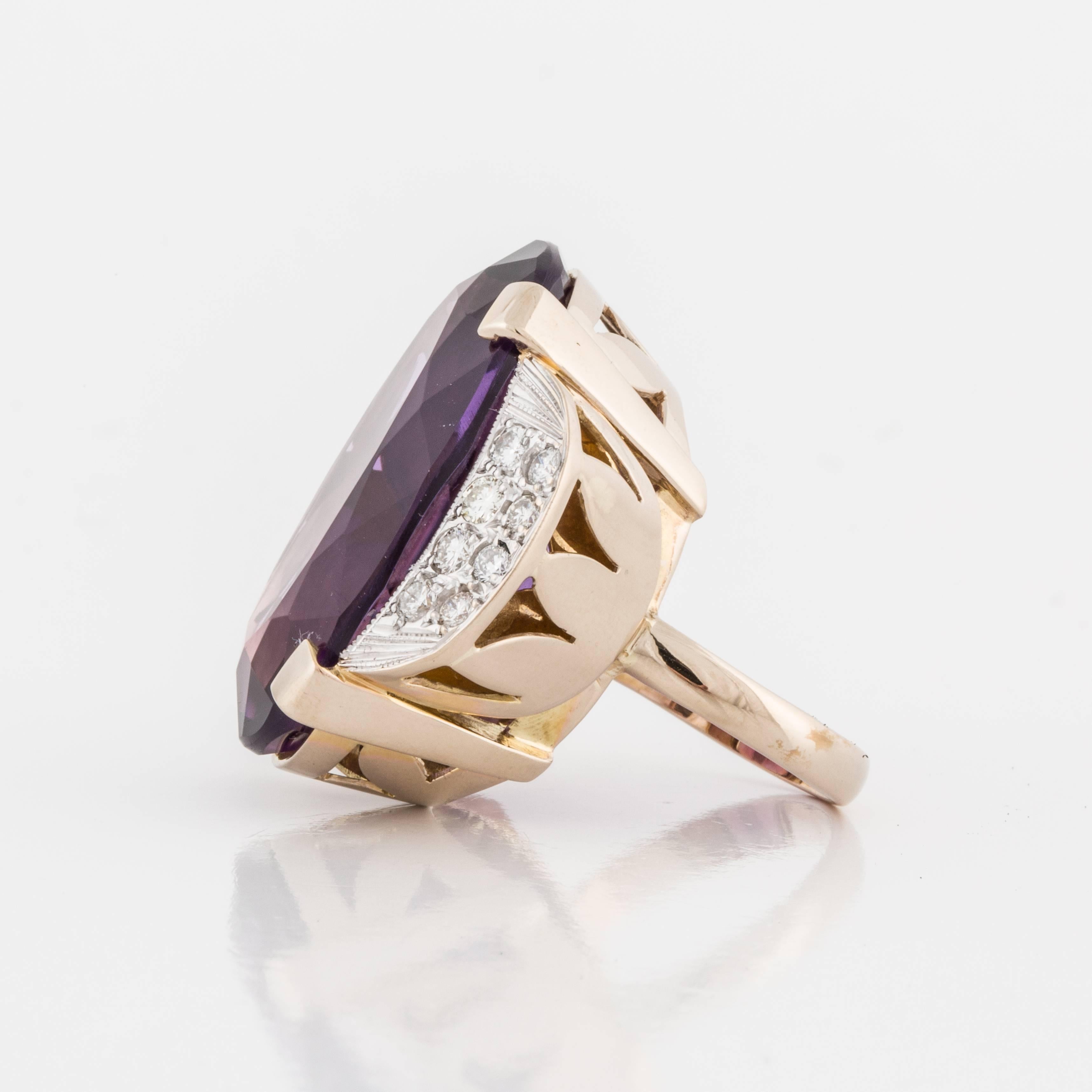 18K yellow gold ring featuring a large amethyst accented by round diamonds.  The oval amethyst measures 1 1/4 inches long by 7/8 inches wide.  There are 16 round diamonds that total 1 carat, G-I color and VS1-SI1 clarity.  Total presentation area
