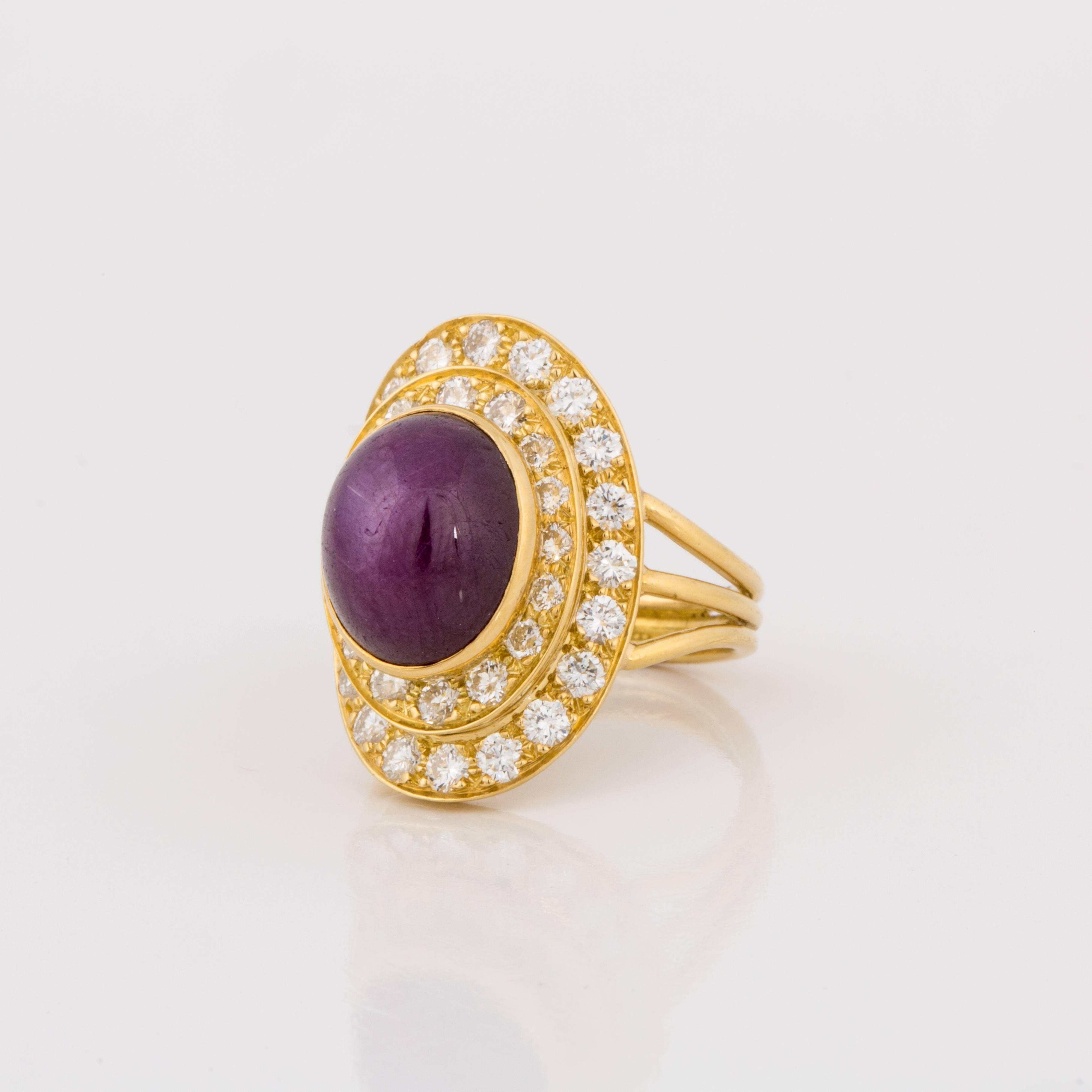 This ring is crafted in 18K yellow gold and features a star ruby which weighs 12 carats.  It is framed by 36 round diamonds that total 2 carats, G-H color and VS1-SI1 clarity.  The ring is currently a size 7 1/2.  Presentation area measures 15/16