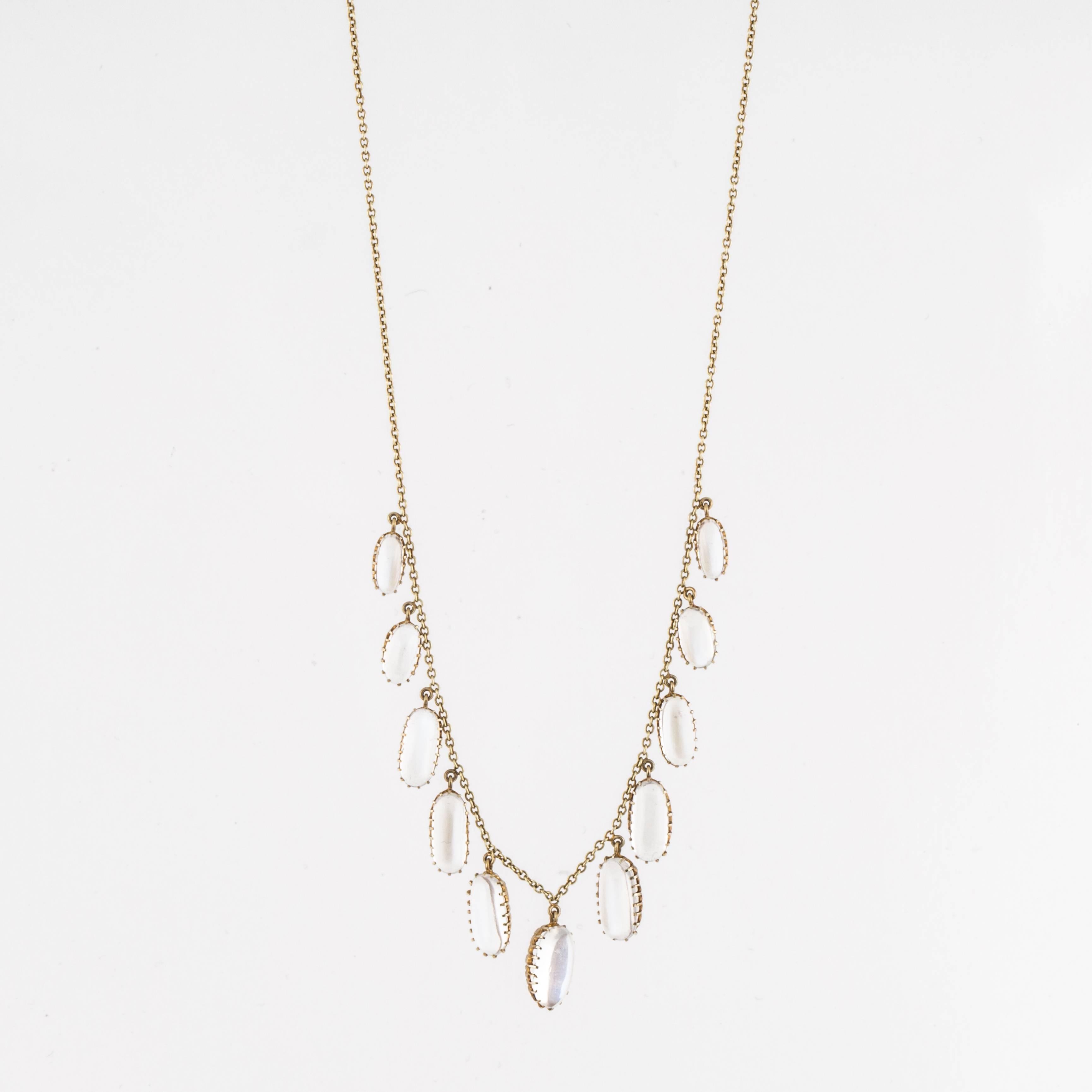 Victorian chain necklace in 15K yellow gold featuring eleven oval moonstones drops. The moonstones are colorless to white body color with blue adularescence.  Marked 