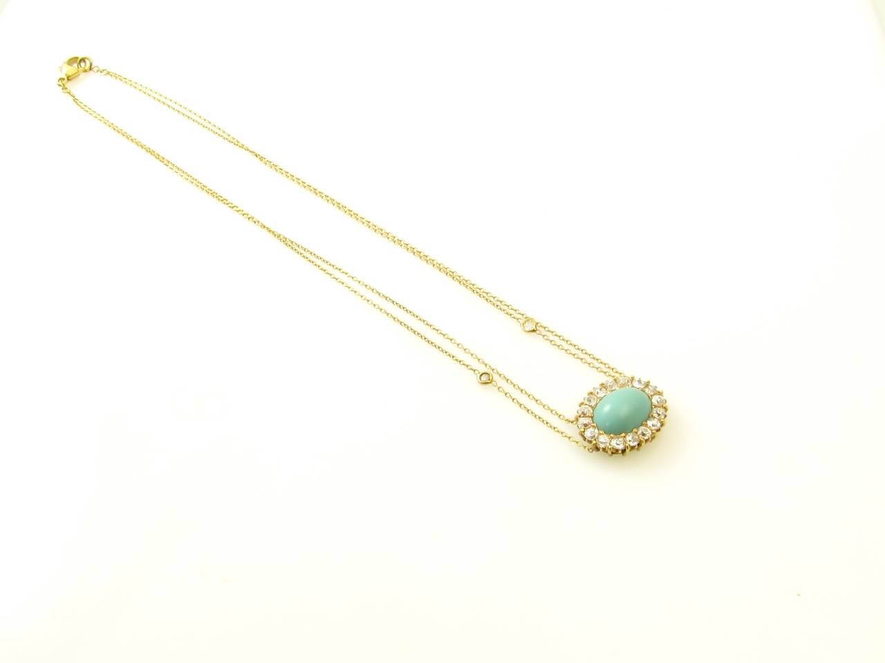 An 18 karat yellow gold, diamond and turquoise necklace with lobster claw clasp, Signed Renee Lewis 18Kt.  The necklace is set with an oval turquoise in a 16 old European cut diamond cluster setting, suspended from a double chain with a collet set